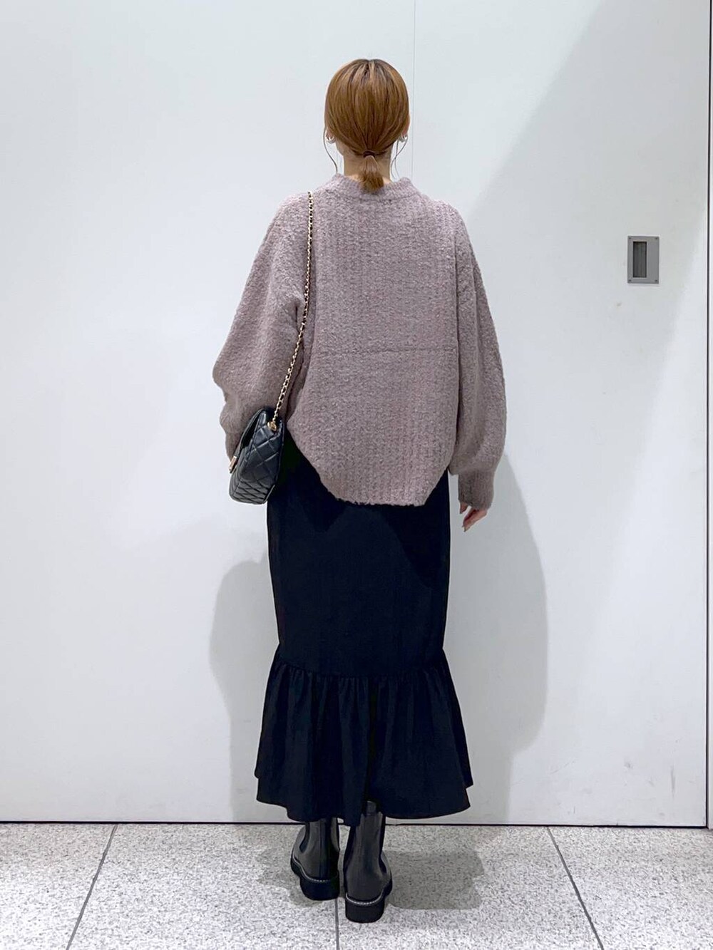 ブラック系のショルダーバッグ、ブラック系のブーツ、ブラウン系のニット/セーターを着用したレディースの秋コーディネートの3枚目の写真