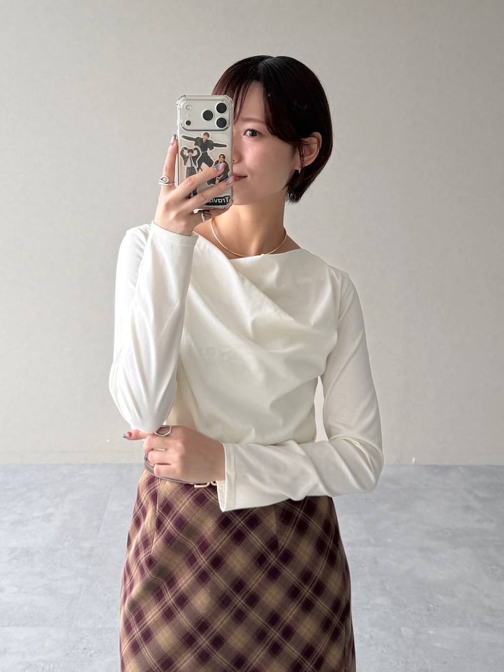 レッド系のスカート、ホワイト系のTシャツ/カットソー、ベージュ系のテーラードジャケットを着用したレディースの秋コーディネートの6枚目の写真