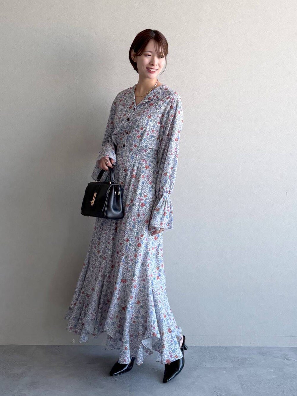 ブラック系のショルダーバッグ、ブラック系のサンダル、ブルー系のトレンチコートを着用したレディースの冬コーディネートの4枚目の写真