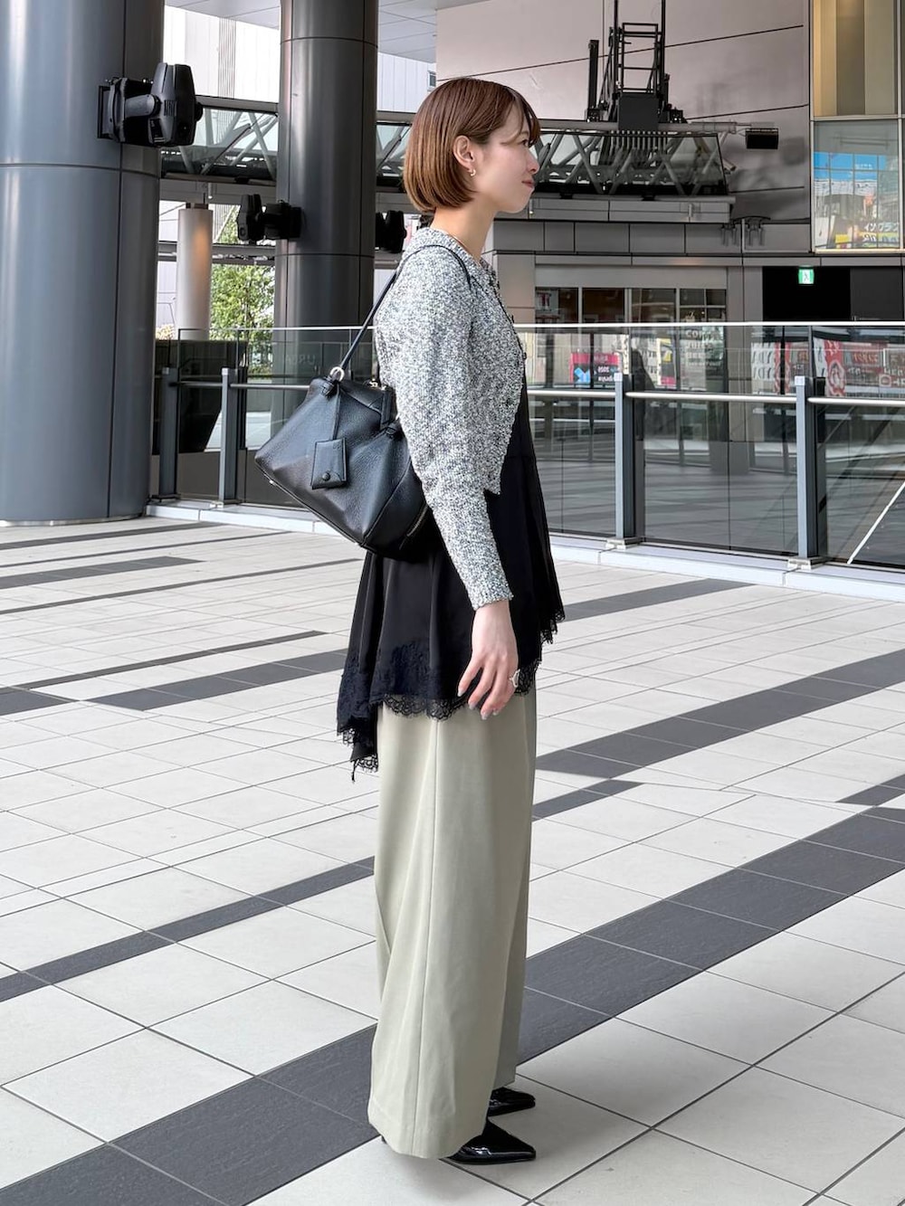 ブラック系のハンドバッグ、ブラック系のサンダル、ブラック系のキャミソールを着用したレディースの春コーディネートの2枚目の写真