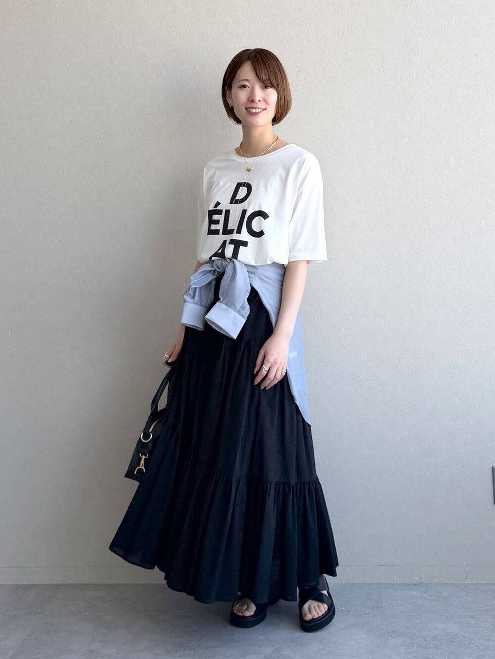 ブラック系のボストンバッグ、ブルー系のシャツ/ブラウス、ブラック系のサンダルを着用したレディースの春コーディネートの6枚目の写真