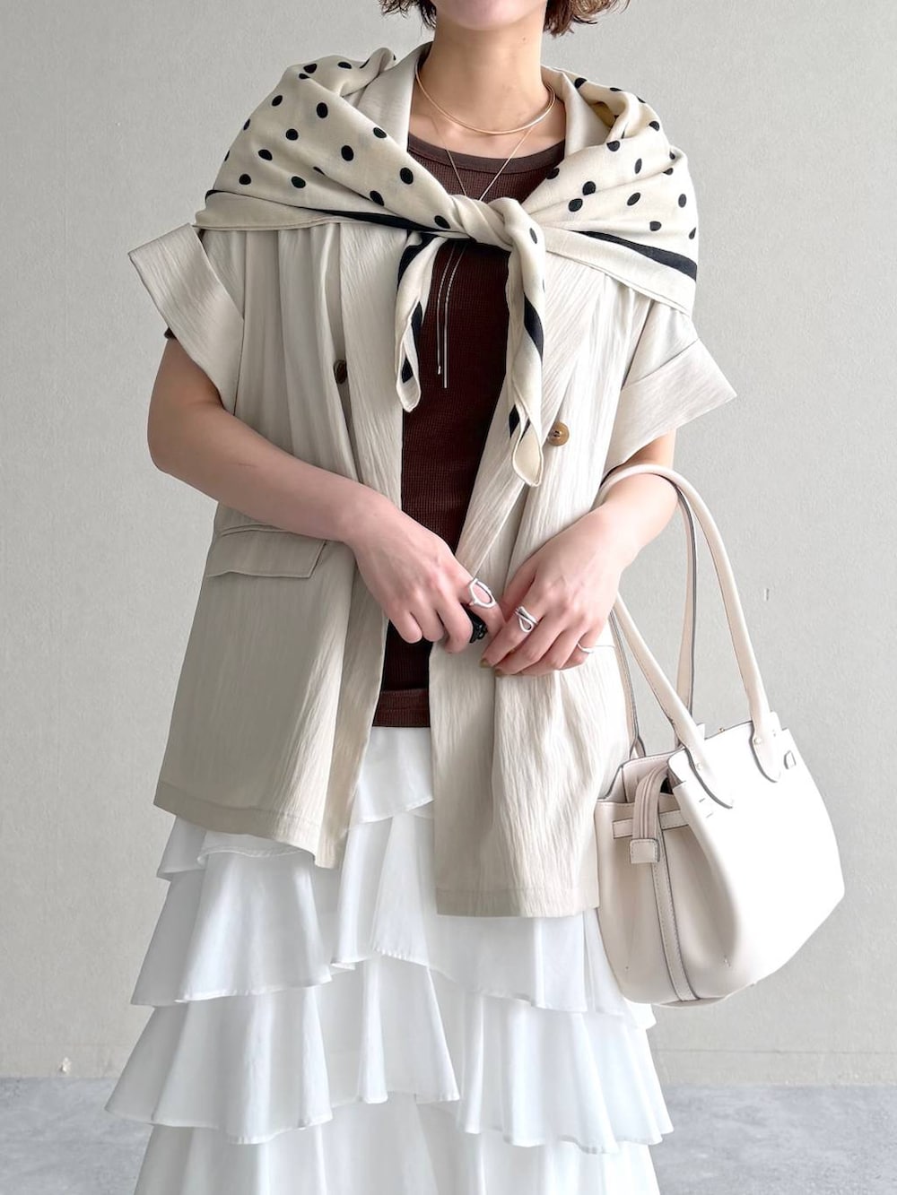 ホワイト系のサンダル、ブラウン系のTシャツ/カットソー、ホワイト系のスカートを着用したレディースの春コーディネートの4枚目の写真