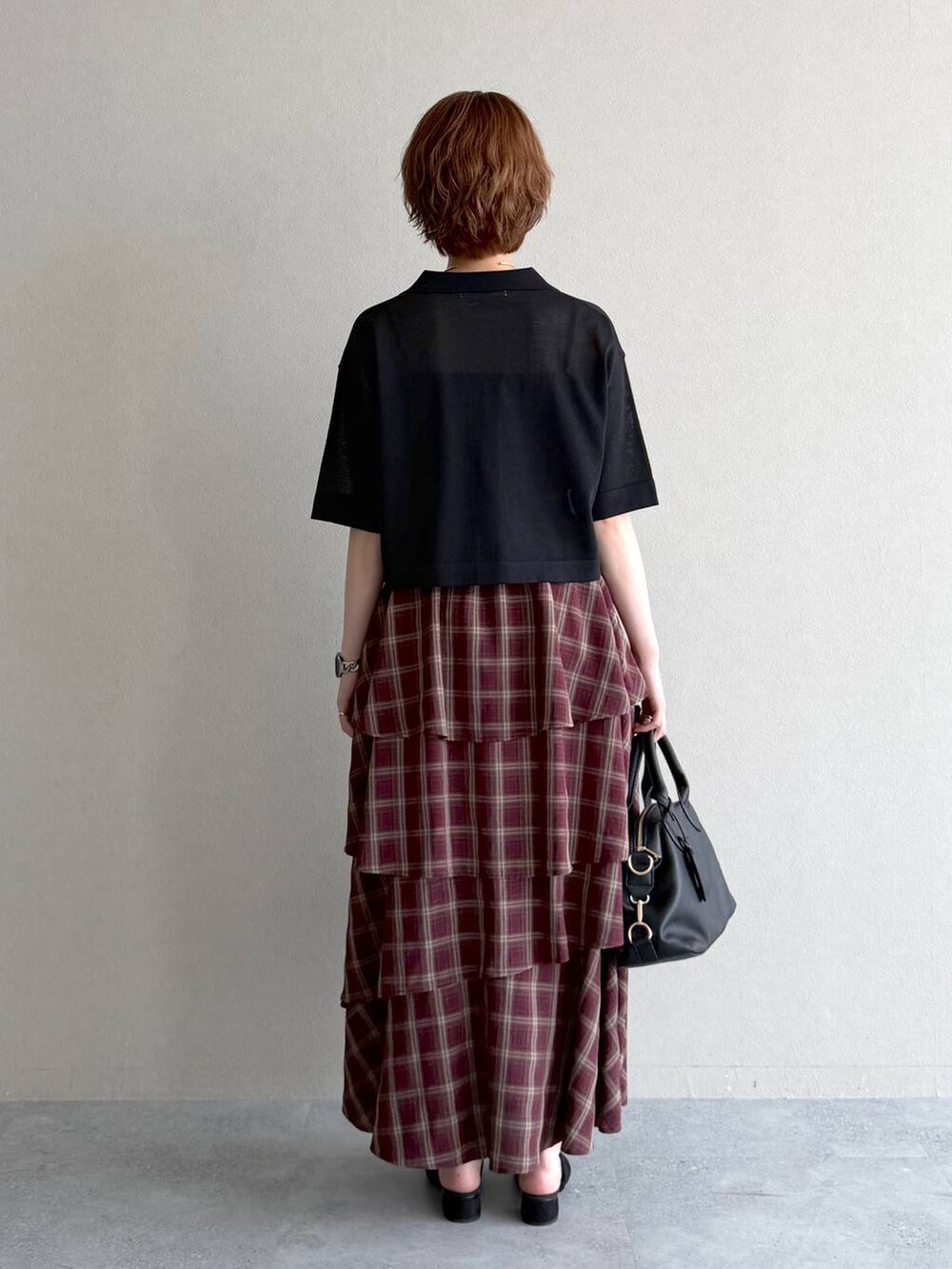 ブラック系のサンダル、レッド系のスカート、ブラック系のニット/セーターを着用したレディースの夏コーディネートの3枚目の写真
