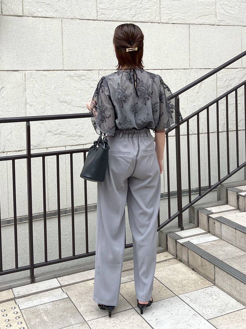 ブラック系のシャツ/ブラウス、ブラック系のサンダル、ブラック系のハンドバッグを着用したレディースの春コーディネートの3枚目の写真