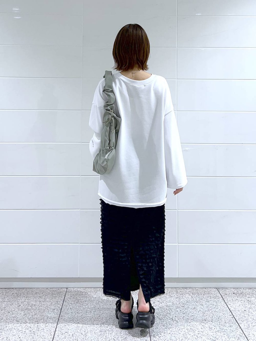 グリーン系のショルダーバッグ、ホワイト系のスウェット、ブラック系のサンダルを着用したレディースの春コーディネートの4枚目の写真