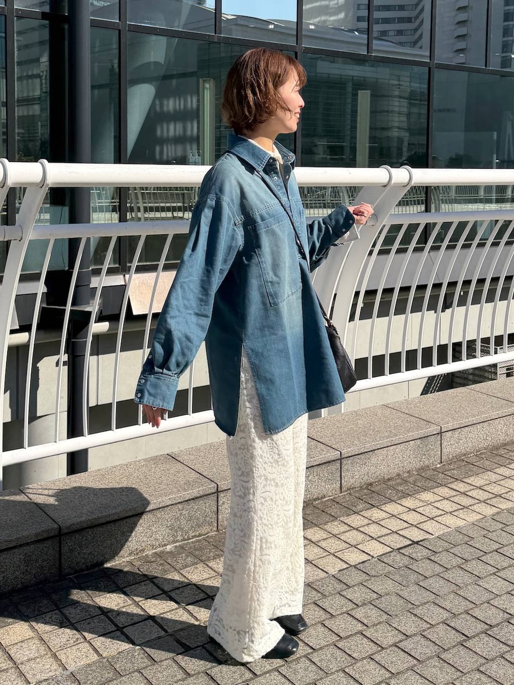 ブラック系のハンドバッグ、ブラック系のローファー、ホワイト系のその他パンツを着用したレディースの冬コーディネートの3枚目の写真