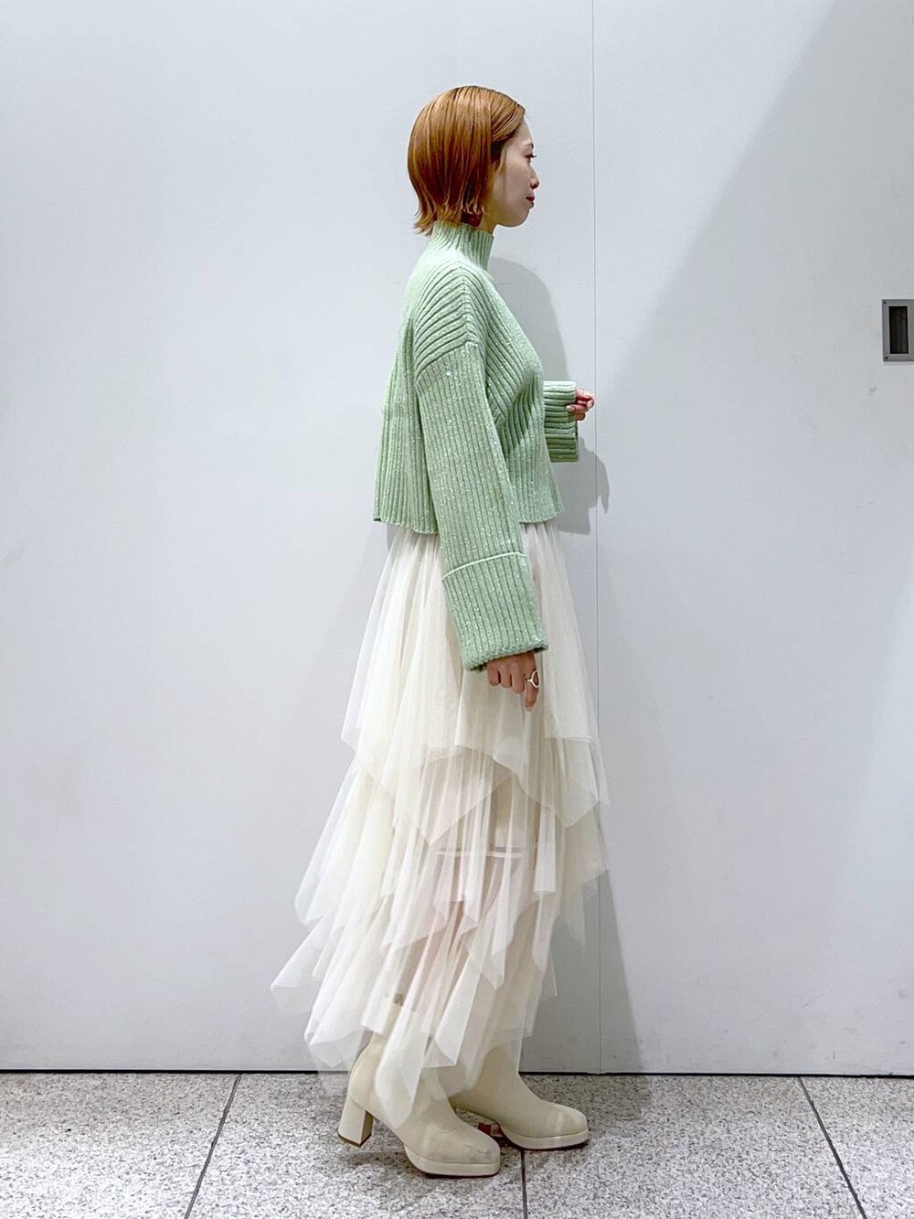 ホワイト系のショルダーバッグ、ホワイト系のブーツ、ホワイト系のスカートを着用したレディースの冬コーディネートの2枚目の写真