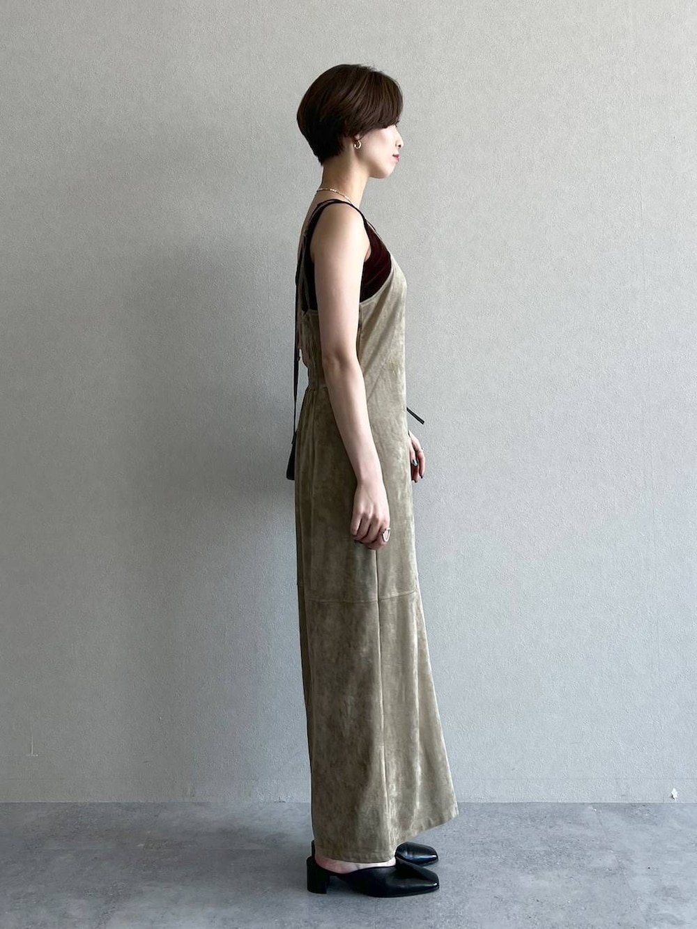 ベージュ系のワンピース、ブラック系のショルダーバッグ、ブラック系のスリッポンを着用したレディースの秋コーディネートの2枚目の写真