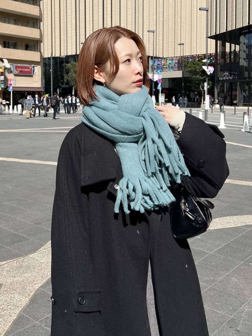 ブラック系のチェスターコート、グレー系のその他パンツ、ホワイト系のニット/セーターを着用したレディースの秋コーディネートの4枚目の写真