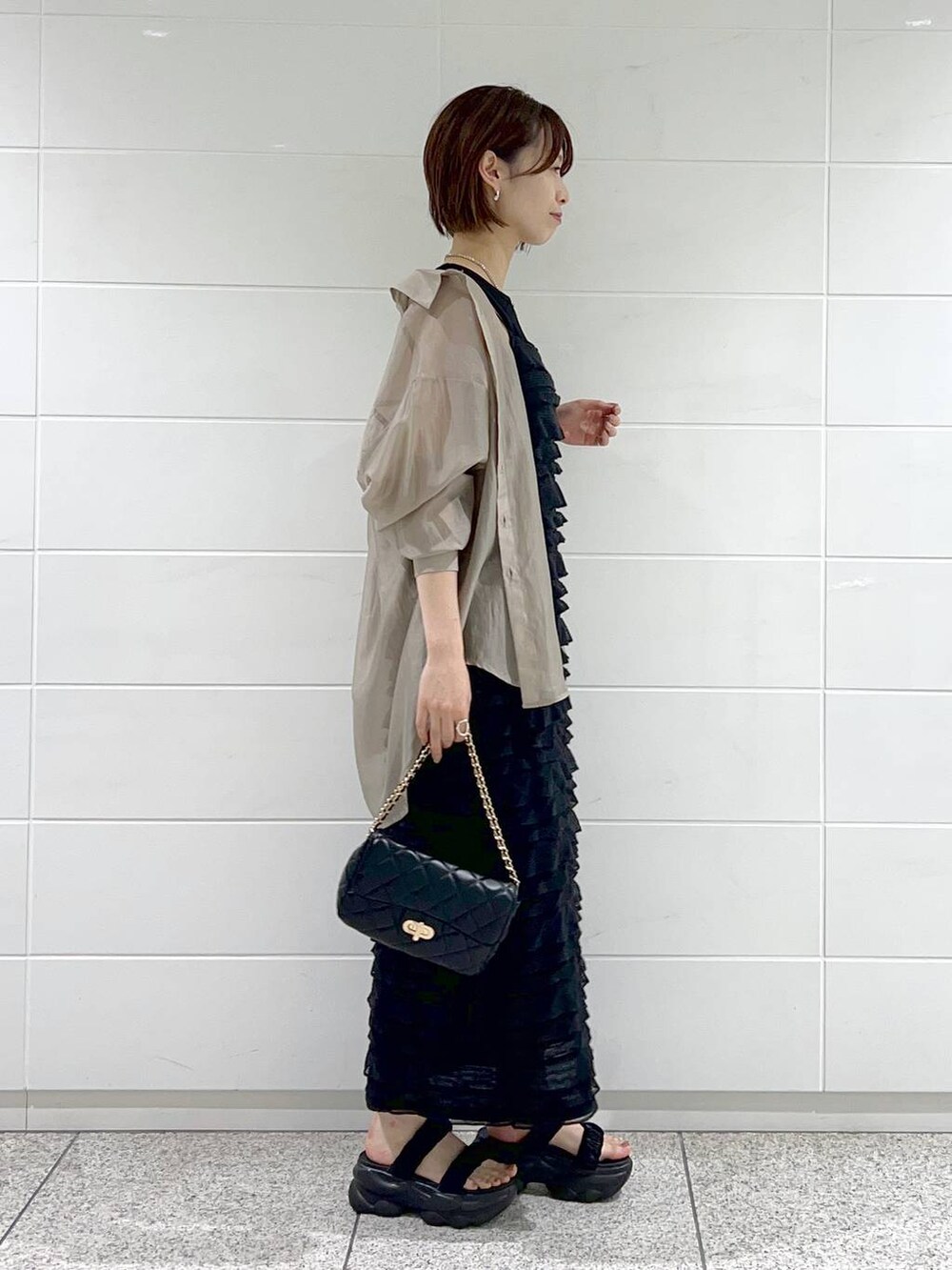 ブラック系のワンピース、ベージュ系のシャツ/ブラウス、ブラック系のショルダーバッグを着用したレディースの夏コーディネートの2枚目の写真