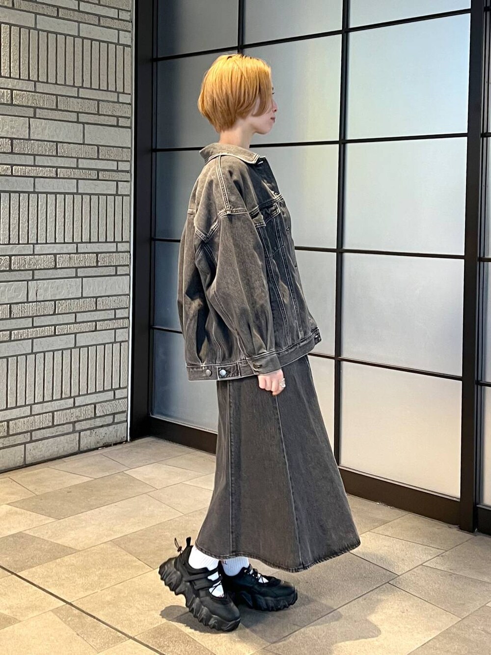 ブラック系のデニムジャケット、ブラック系のジャンパースカート、ブラック系のバレエシューズを着用したレディースの冬コーディネートの2枚目の写真