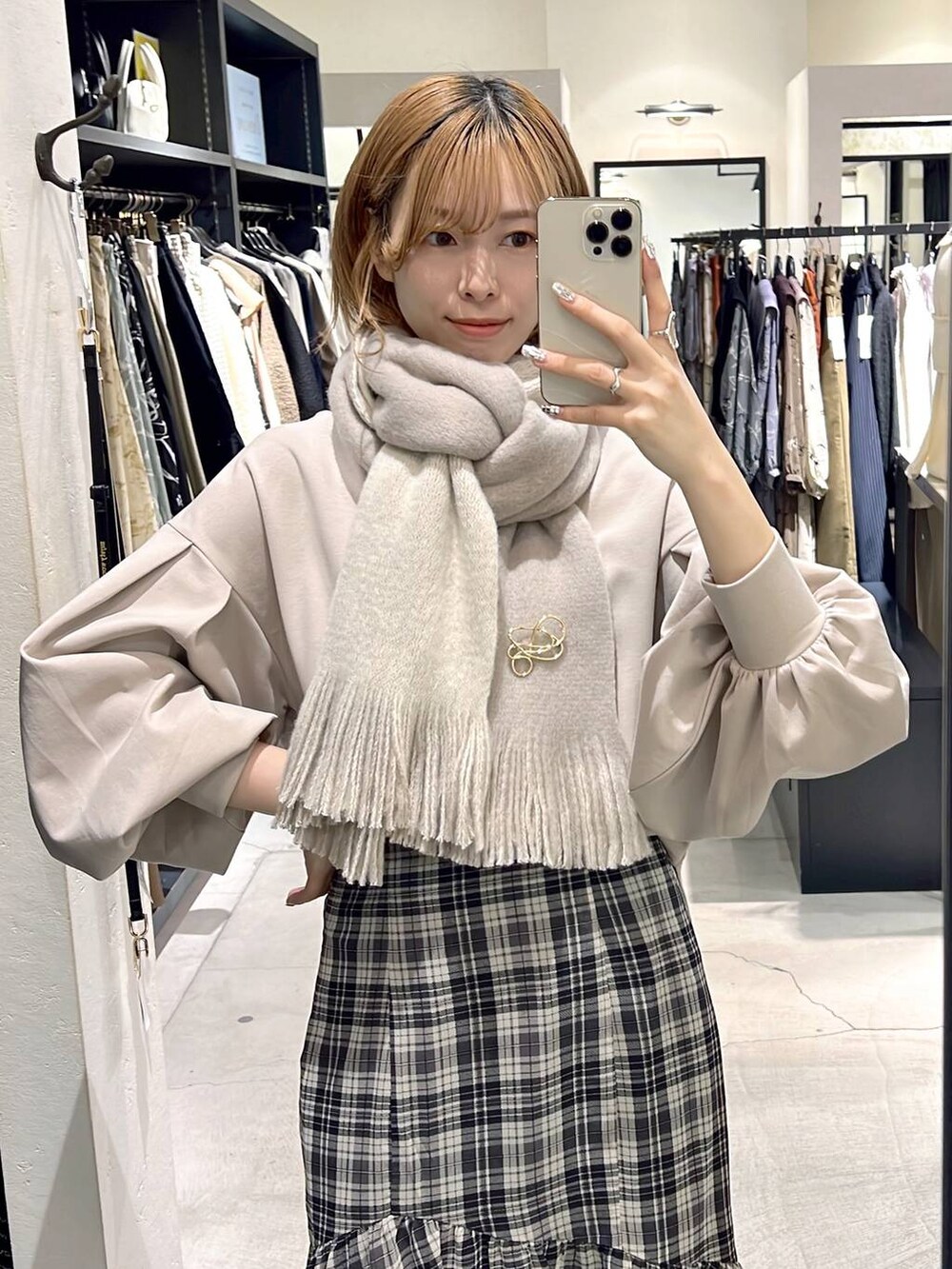 ホワイト系のボストンバッグ、ベージュ系のTシャツ/カットソー、ブラック系のブーツを着用したレディースの秋コーディネートの4枚目の写真