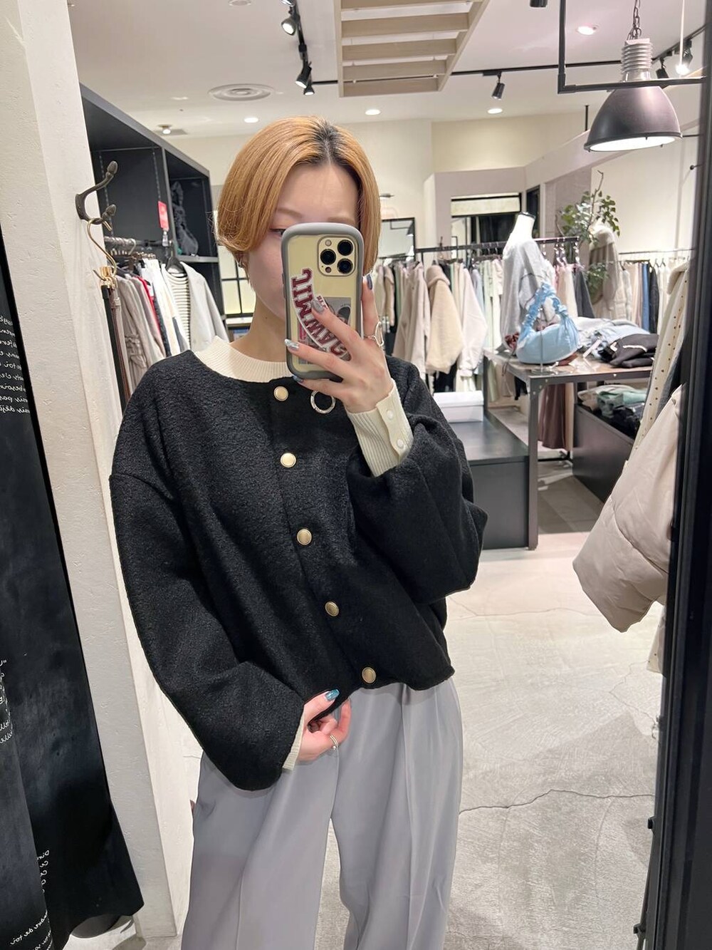 ブラック系のショルダーバッグ、ブラック系のブーツ、ホワイト系のニット/セーターを着用したレディースの冬コーディネートの4枚目の写真