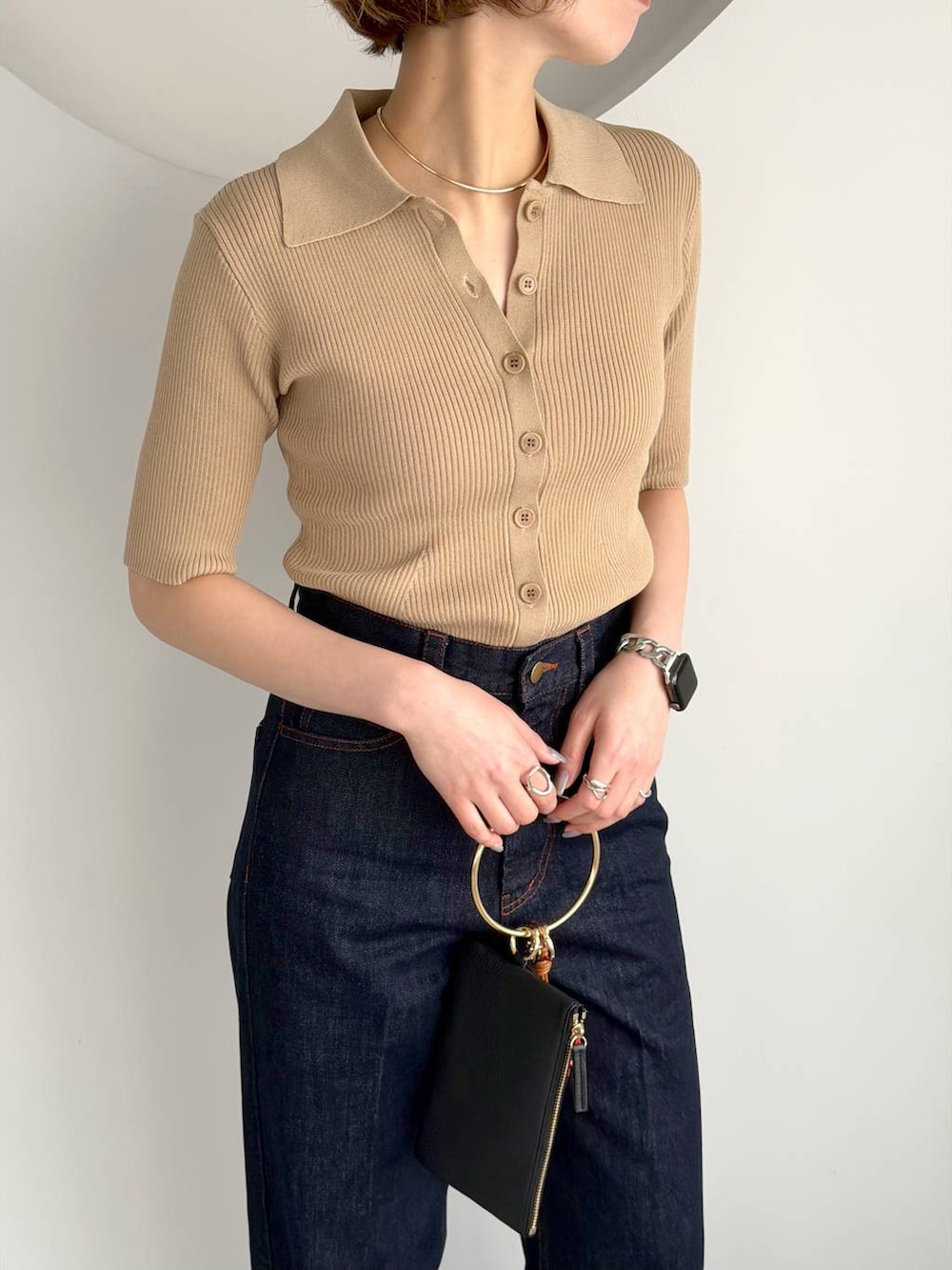 ブルー系のパンプス、ブラック系のショルダーバッグ、ブルー系のデニムパンツを着用したレディースの春コーディネートの4枚目の写真