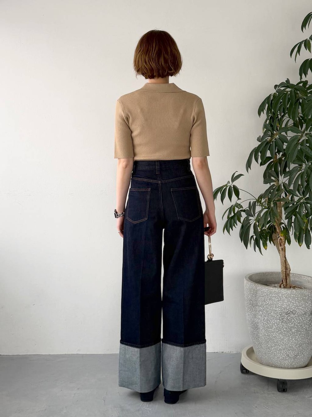 ブルー系のパンプス、ブラック系のショルダーバッグ、ブルー系のデニムパンツを着用したレディースの春コーディネートの3枚目の写真