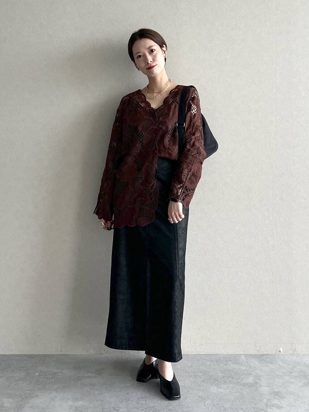 ブラウン系のシャツ/ブラウス、ブラック系のスカート、ブラック系のスリッポンを着用したレディースの秋コーディネートの4枚目の写真