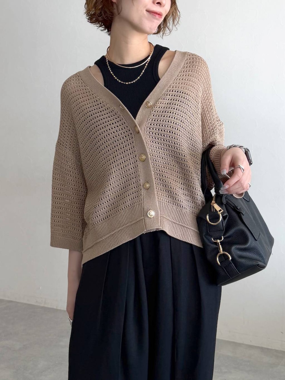 ブラック系のボストンバッグ、ブラック系のサンダル、ブラック系のタンクトップを着用したレディースの春コーディネートの4枚目の写真