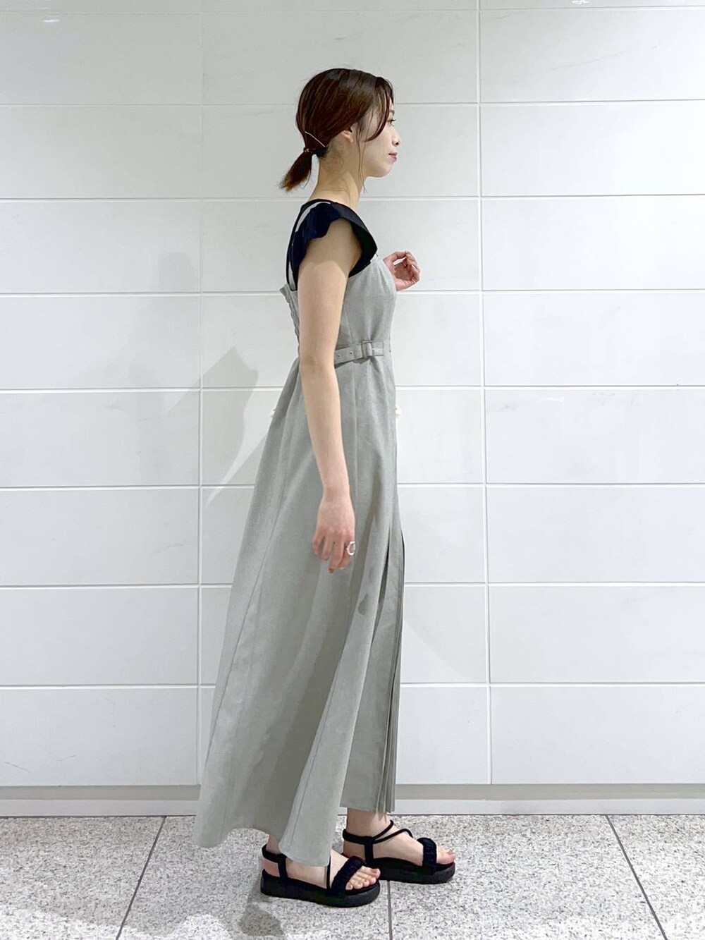 ブラック系のサンダル、ホワイト系のハンドバッグ、ブラック系のTシャツ/カットソーを着用したレディースの春コーディネートの2枚目の写真