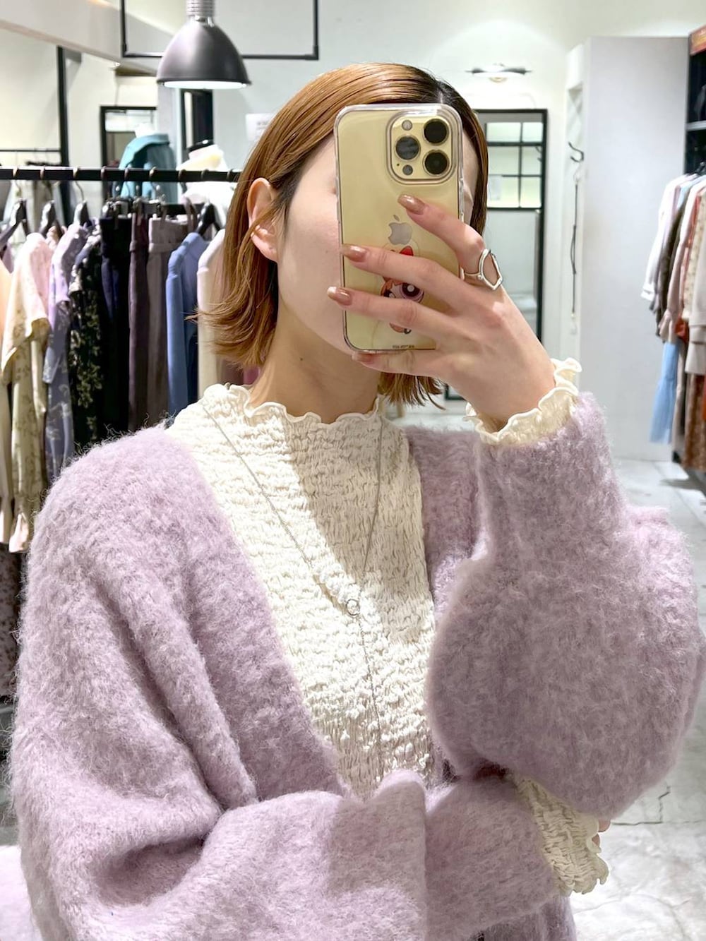 ブラック系のブーツ、ピンク系のカーディガン/ボレロ、シルバー系のトートバッグを着用したレディースの冬コーディネートの5枚目の写真