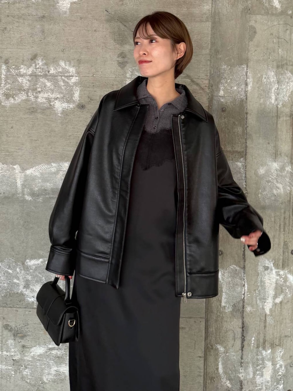 ブラック系のショルダーバッグ、ブラック系のデニムパンツ、ブラック系のパンプスを着用したレディースの冬コーディネートの5枚目の写真