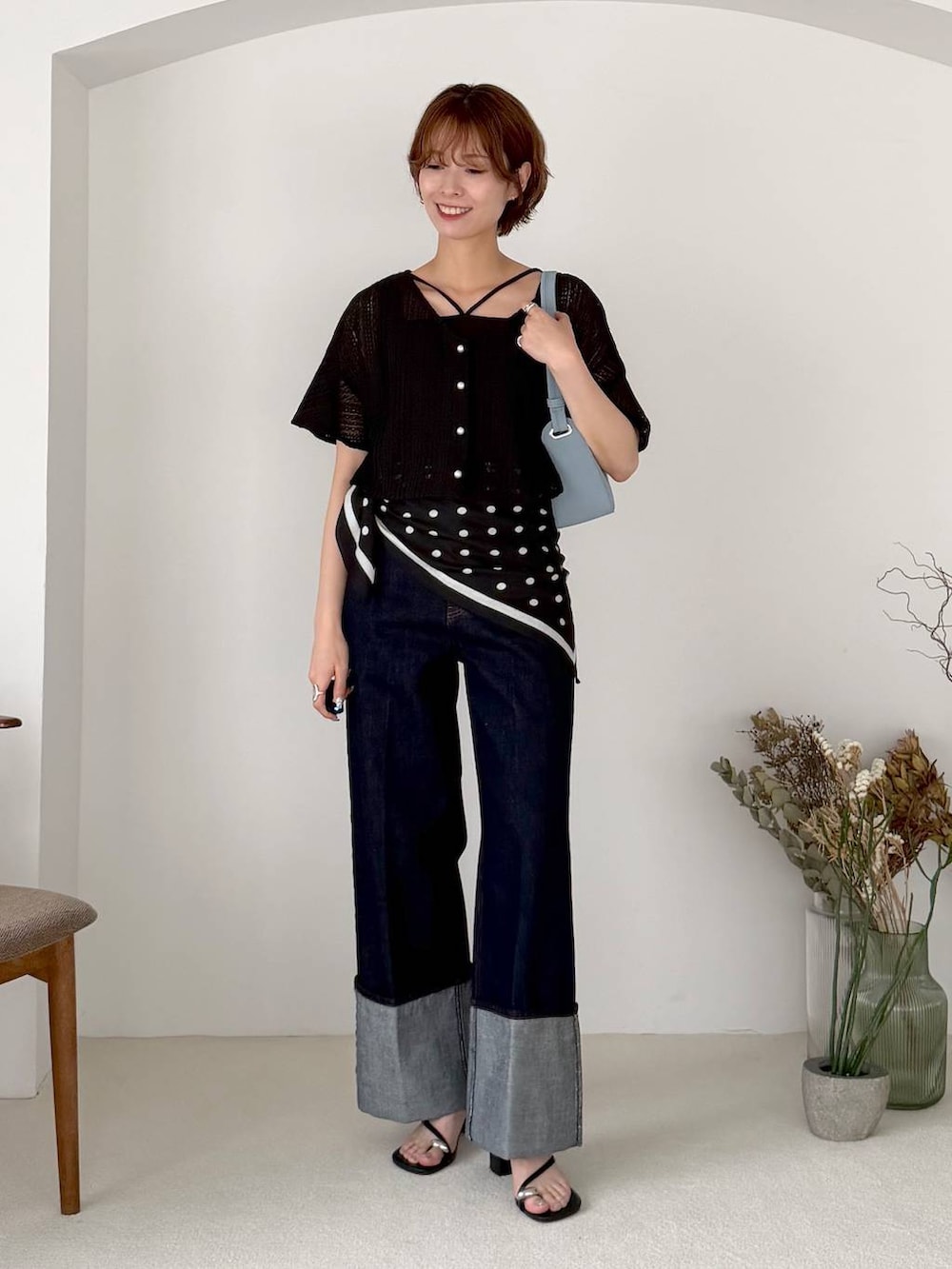 ブラック系のアンサンブル、ブルー系のデニムパンツ、ブラック系のサンダルを着用したレディースの夏コーディネートの4枚目の写真