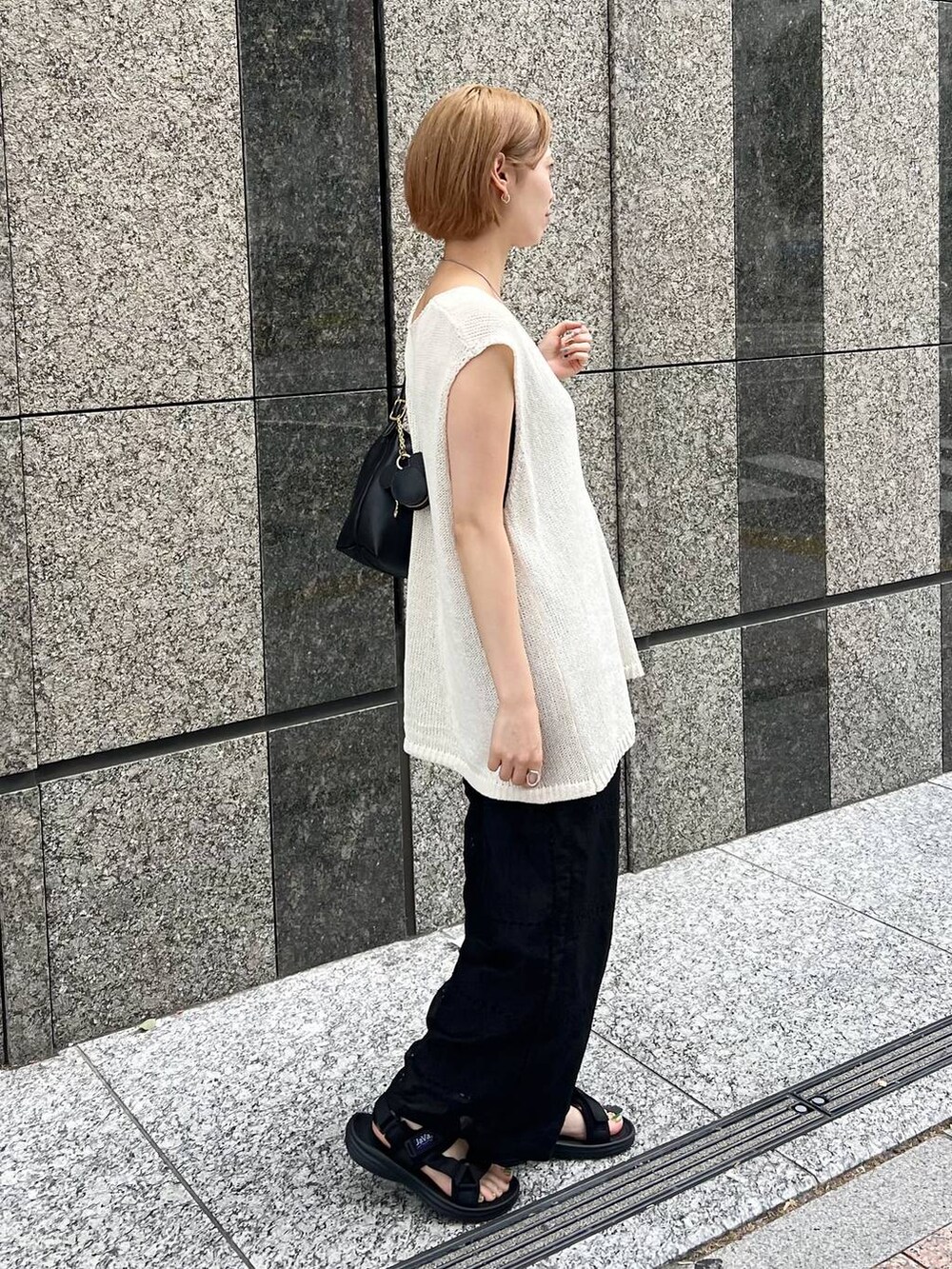 ホワイト系のニット/セーター、ブラック系のキャミソール、ブラック系のその他パンツを着用したレディースの夏コーディネートの5枚目の写真