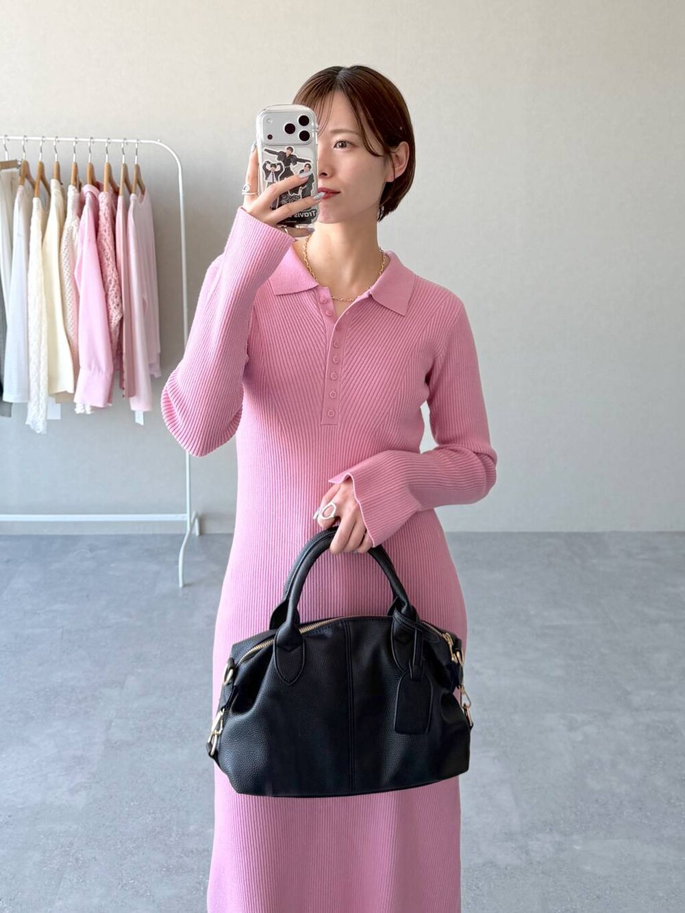 ブラック系のボストンバッグ、ピンク系のワンピース、ブルー系のデニムパンツを着用したレディースの冬コーディネートの4枚目の写真