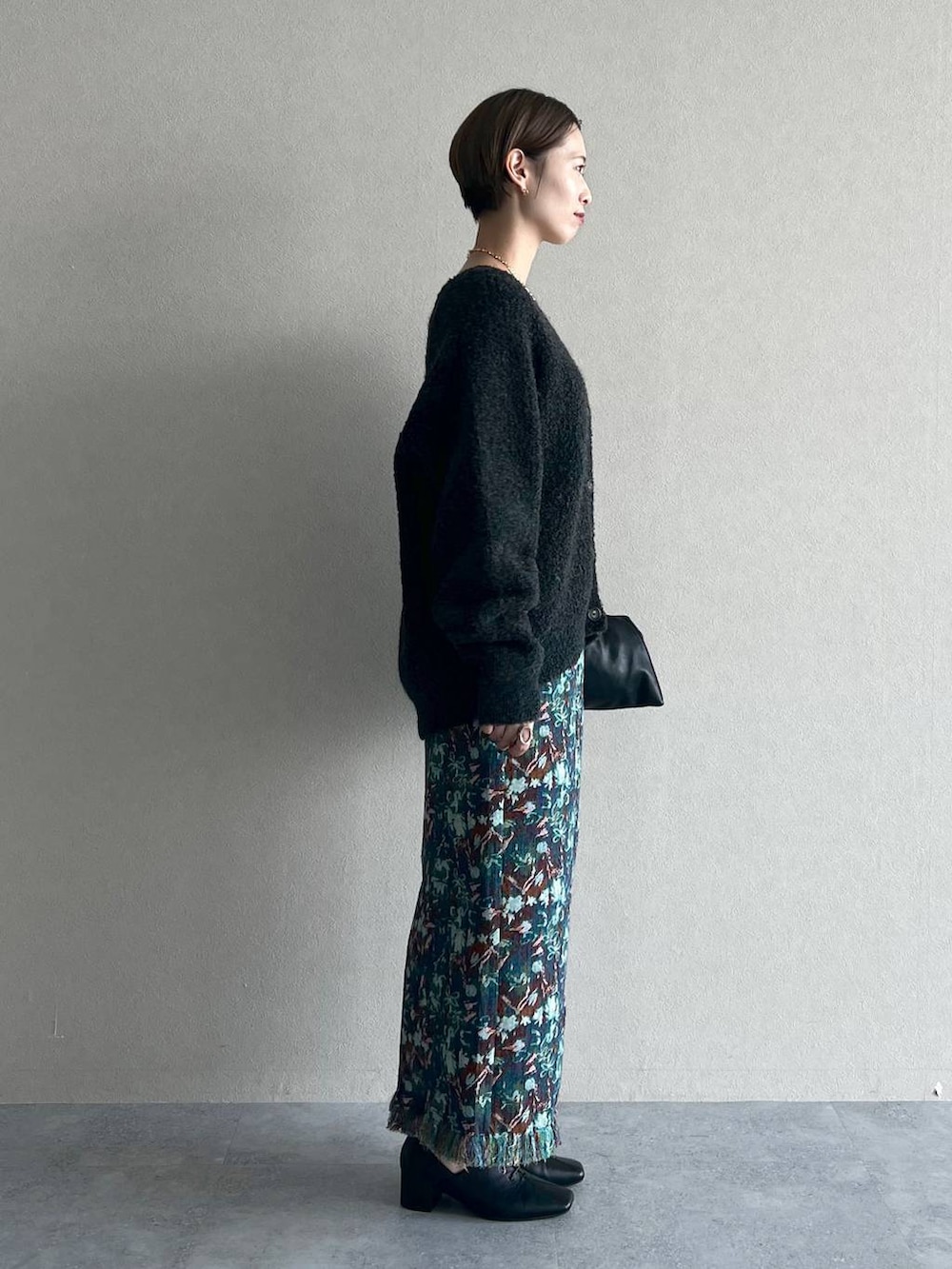 ブラック系のハンドバッグ、グレー系のカーディガン/ボレロ、ブラック系のタンクトップを着用したレディースの秋コーディネートの2枚目の写真