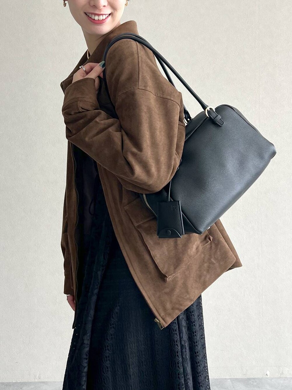 ブラック系のハンドバッグ、ブラック系のワンピース、ブラック系のドレスシューズを着用したレディースの秋コーディネートの5枚目の写真