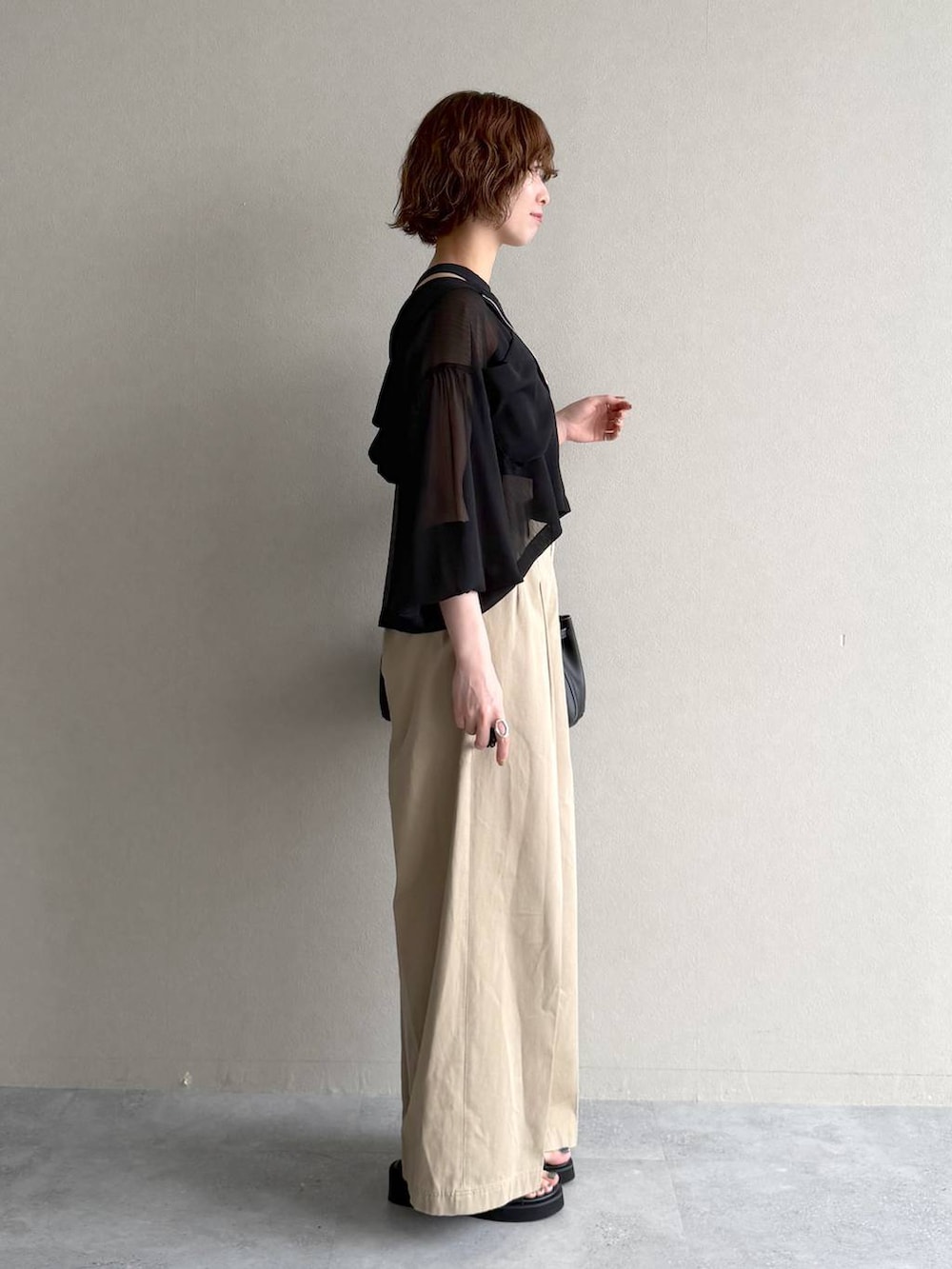 ブラック系のパーカー、ブラック系のサンダル、ブラック系のニット/セーターを着用したレディースの春コーディネートの2枚目の写真