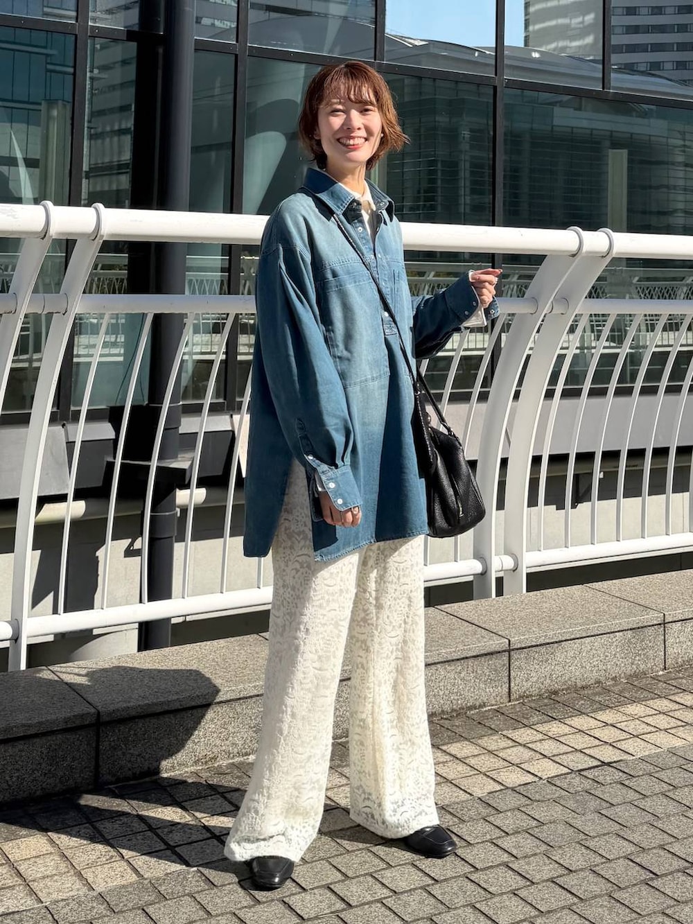 ブラック系のハンドバッグ、ブラック系のローファー、ホワイト系のその他パンツを着用したレディースの冬コーディネートの2枚目の写真