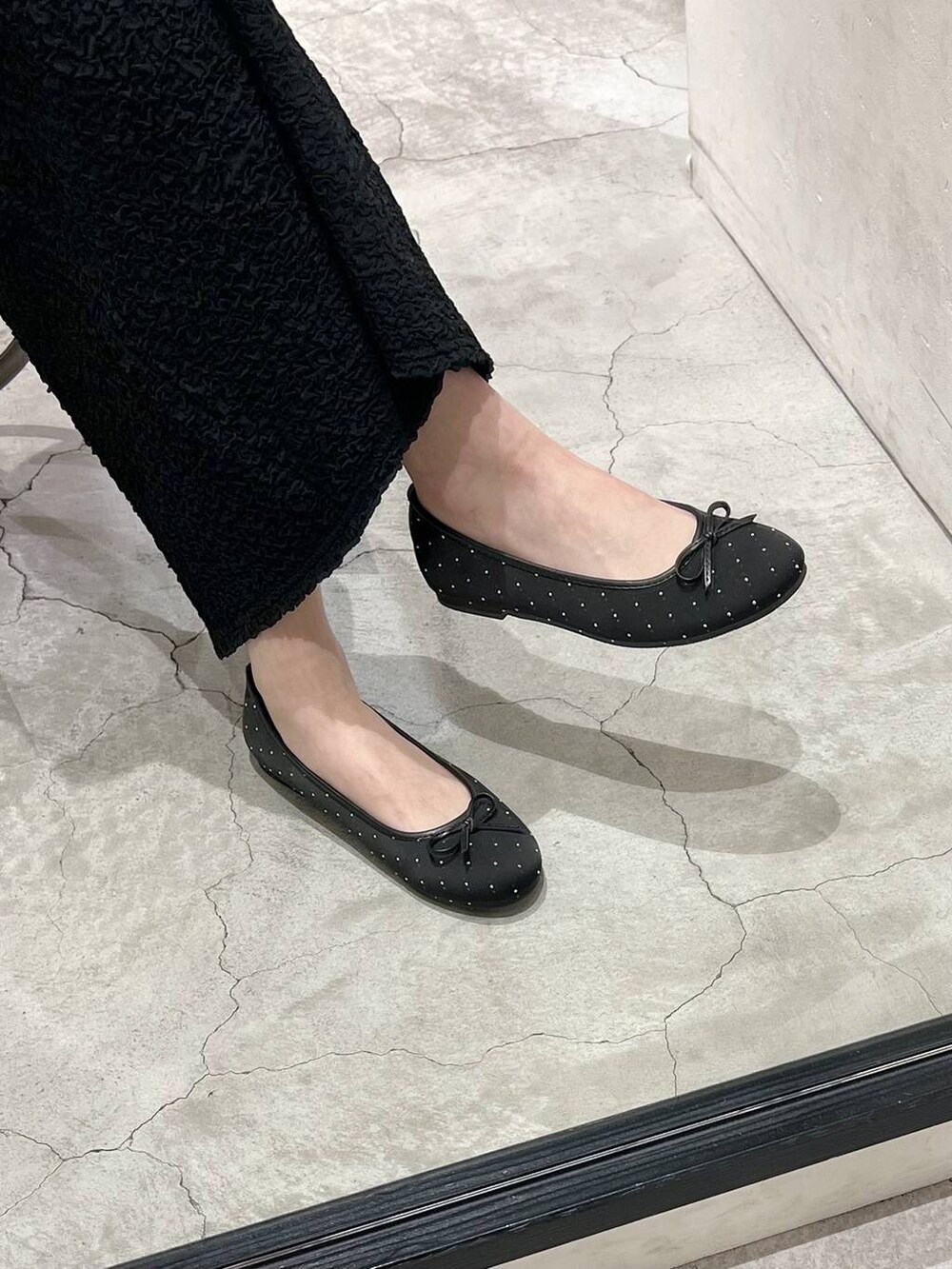 ブラック系のショルダーバッグ、ブラック系のマウンテンパーカー、ブラック系のバレエシューズを着用したレディースの春コーディネートの6枚目の写真