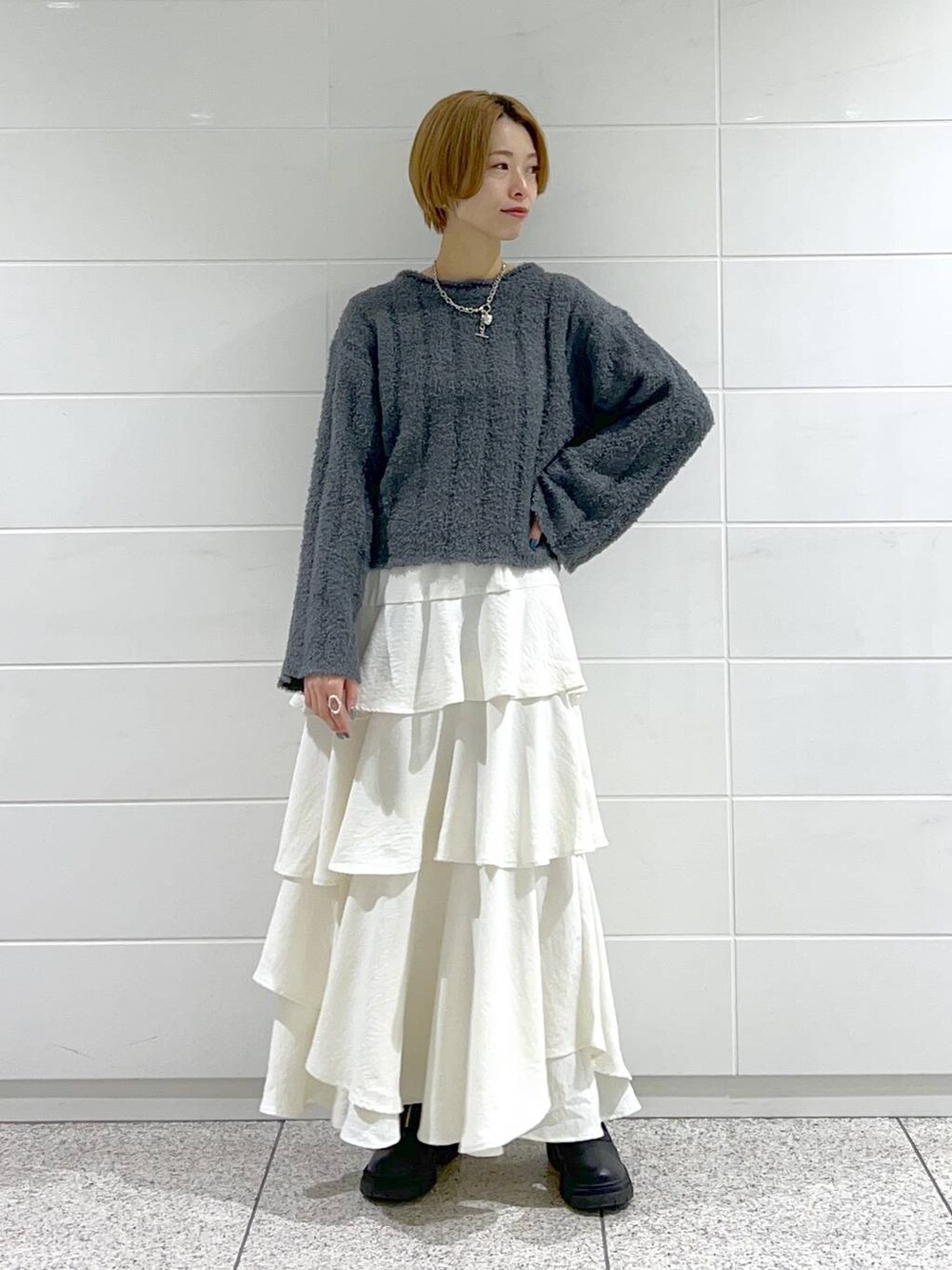 ブラック系のブーツ、ホワイト系のスカート、ブラック系のブルゾンを着用したレディースの冬コーディネートの4枚目の写真