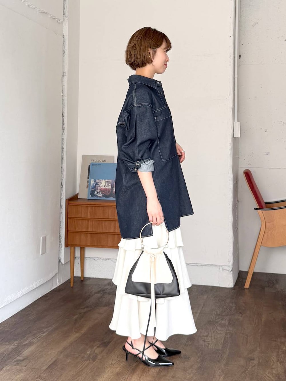 ホワイト系のスカート、ブラック系のサンダル、ブルー系のシャツ/ブラウスを着用したレディースの春コーディネートの2枚目の写真