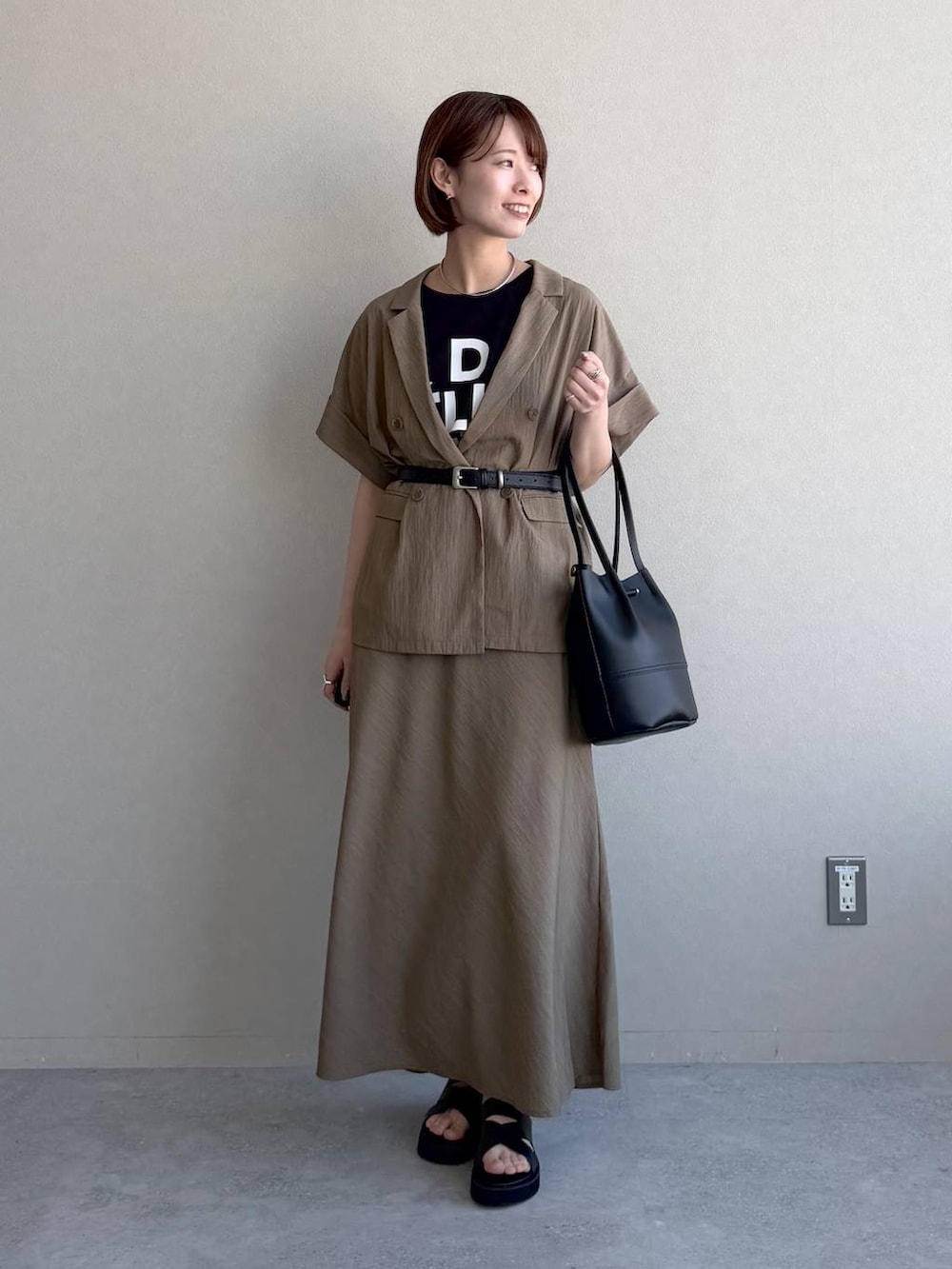 ブラック系のサンダル、ブラック系のTシャツ/カットソー、ブラウン系のスカートを着用したレディースの春コーディネートの5枚目の写真