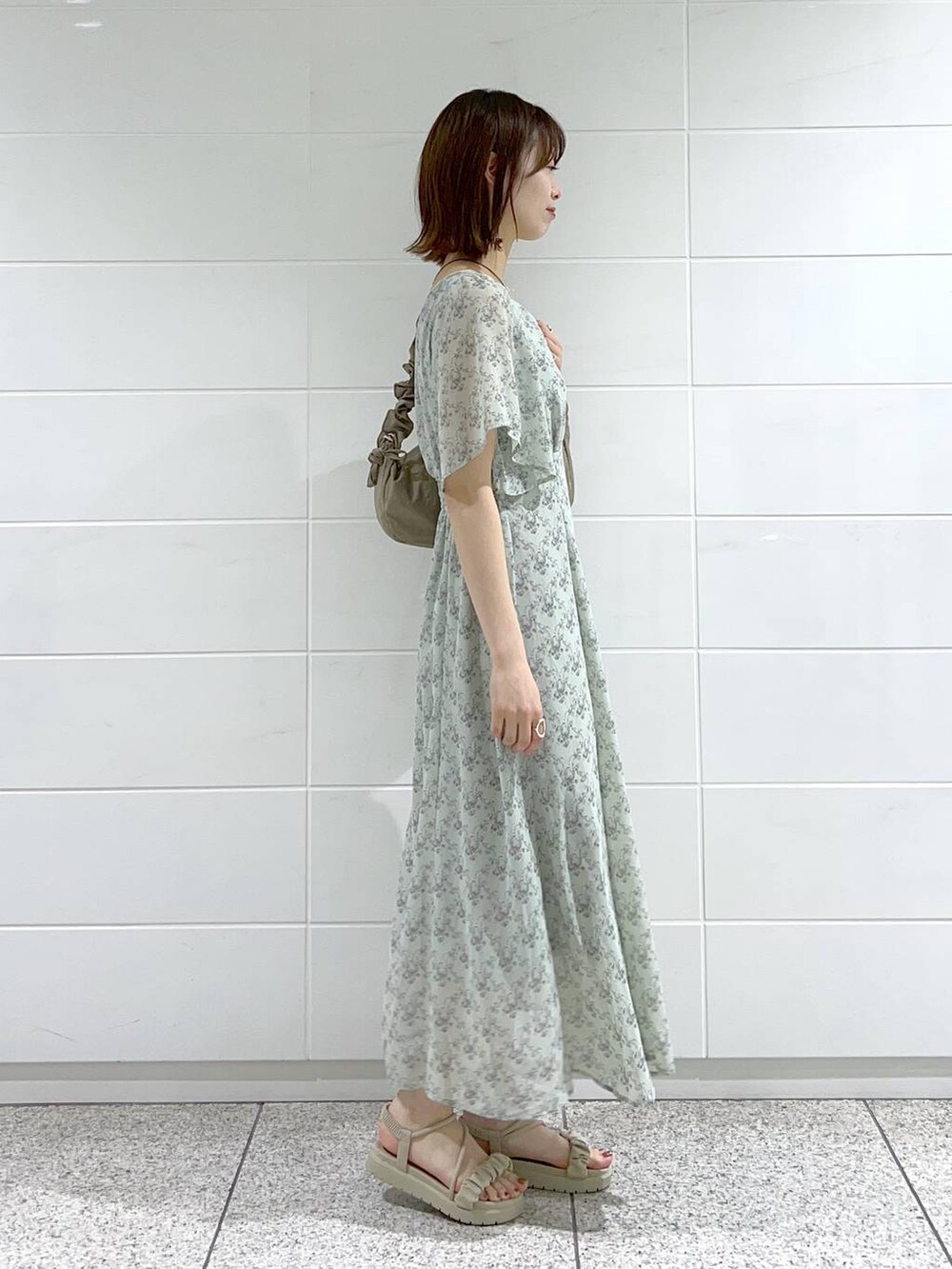 グレー系のサンダル、グリーン系のワンピース、ブラウン系のショルダーバッグを着用したレディースの春コーディネートの3枚目の写真