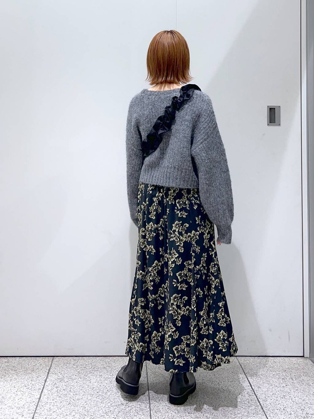 ブラック系のハンドバッグ、ブラック系のブーツ、ブラック系のスカートを着用したレディースの秋コーディネートの3枚目の写真