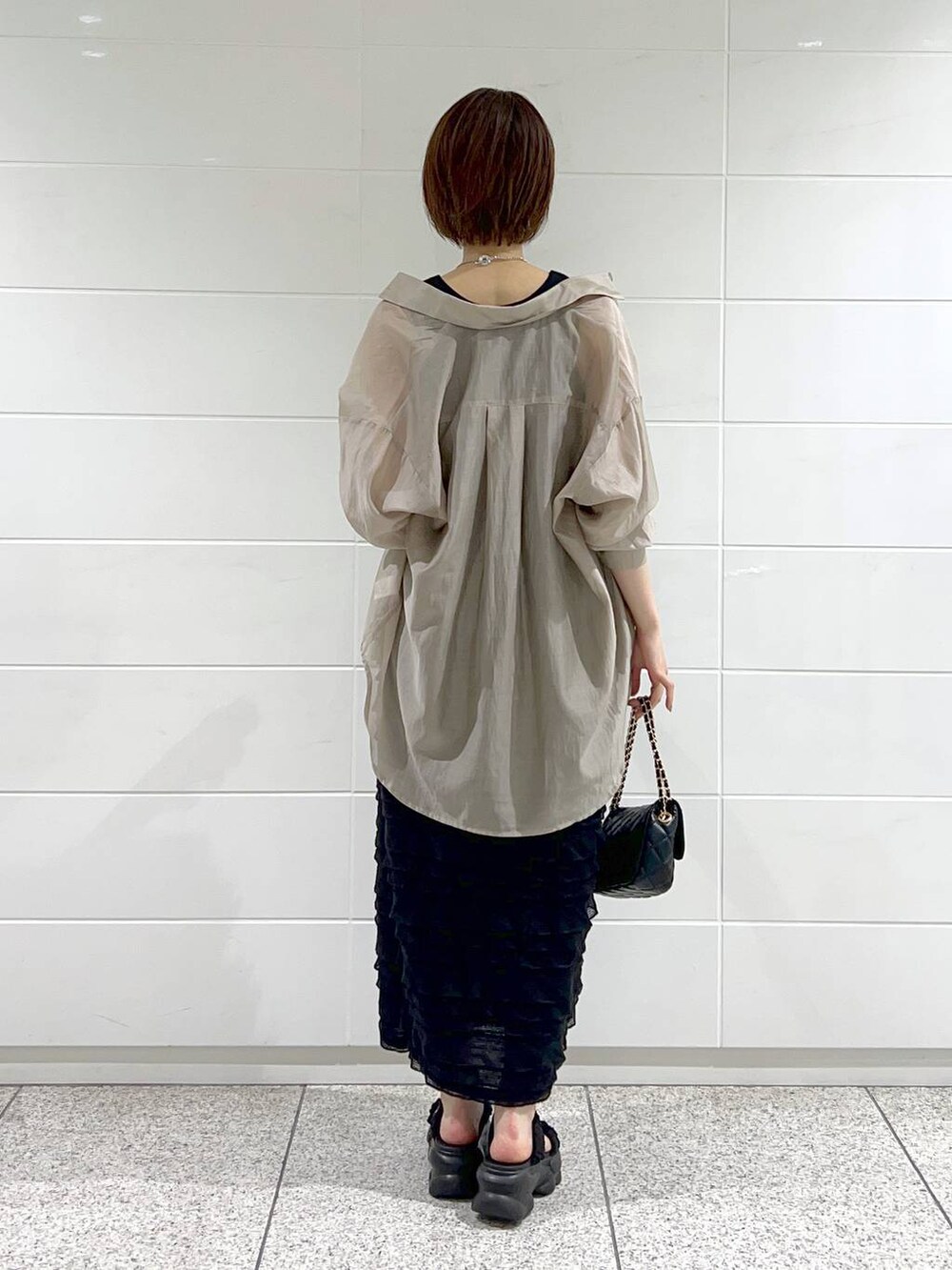 ブラック系のワンピース、ベージュ系のシャツ/ブラウス、ブラック系のショルダーバッグを着用したレディースの夏コーディネートの3枚目の写真