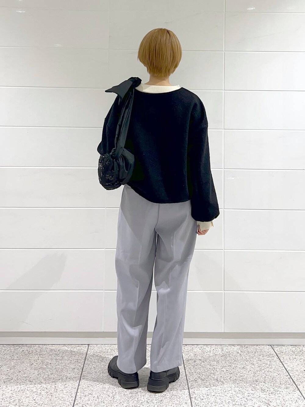 ブラック系のショルダーバッグ、ブラック系のブーツ、ホワイト系のニット/セーターを着用したレディースの冬コーディネートの3枚目の写真