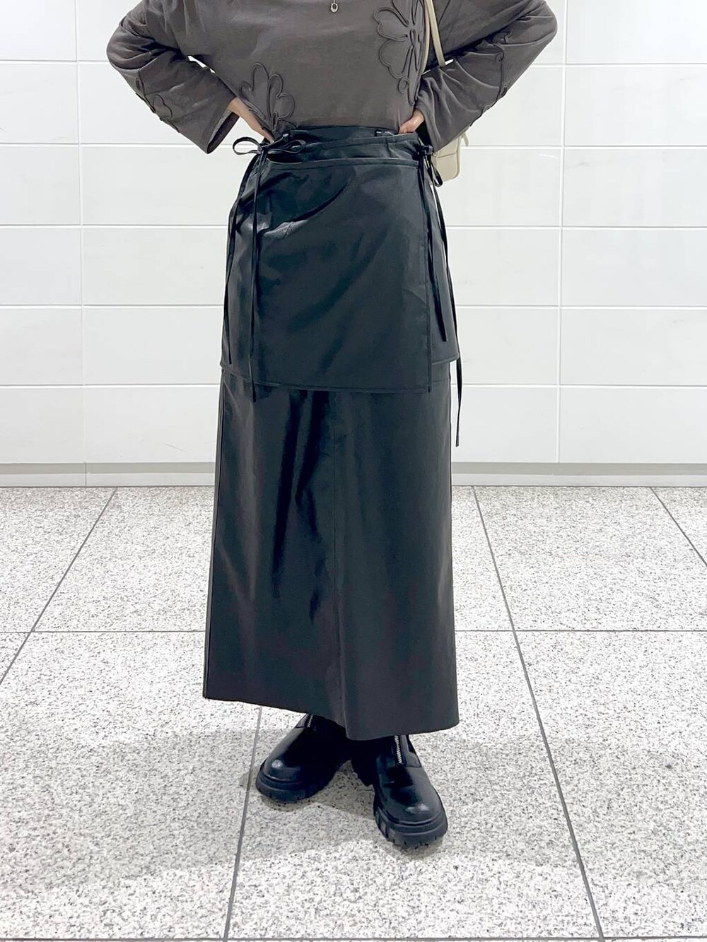 ブラック系のブーツ、グレー系のTシャツ/カットソー、ブラック系のスカートを着用したレディースの秋コーディネートの6枚目の写真