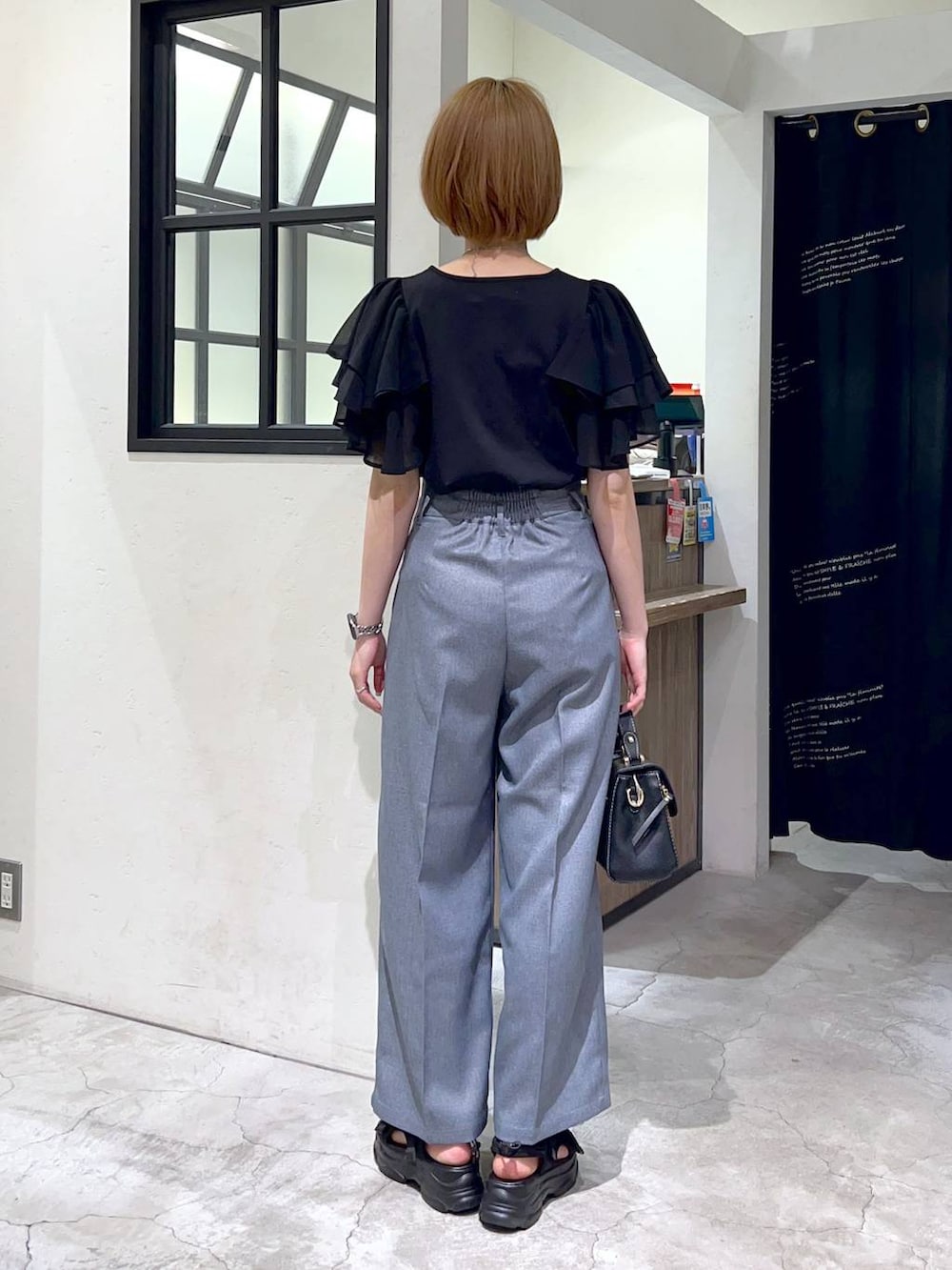 ブラック系のサンダル、ブラック系のショルダーバッグ、ブラック系のTシャツ/カットソーを着用したレディースの夏コーディネートの3枚目の写真