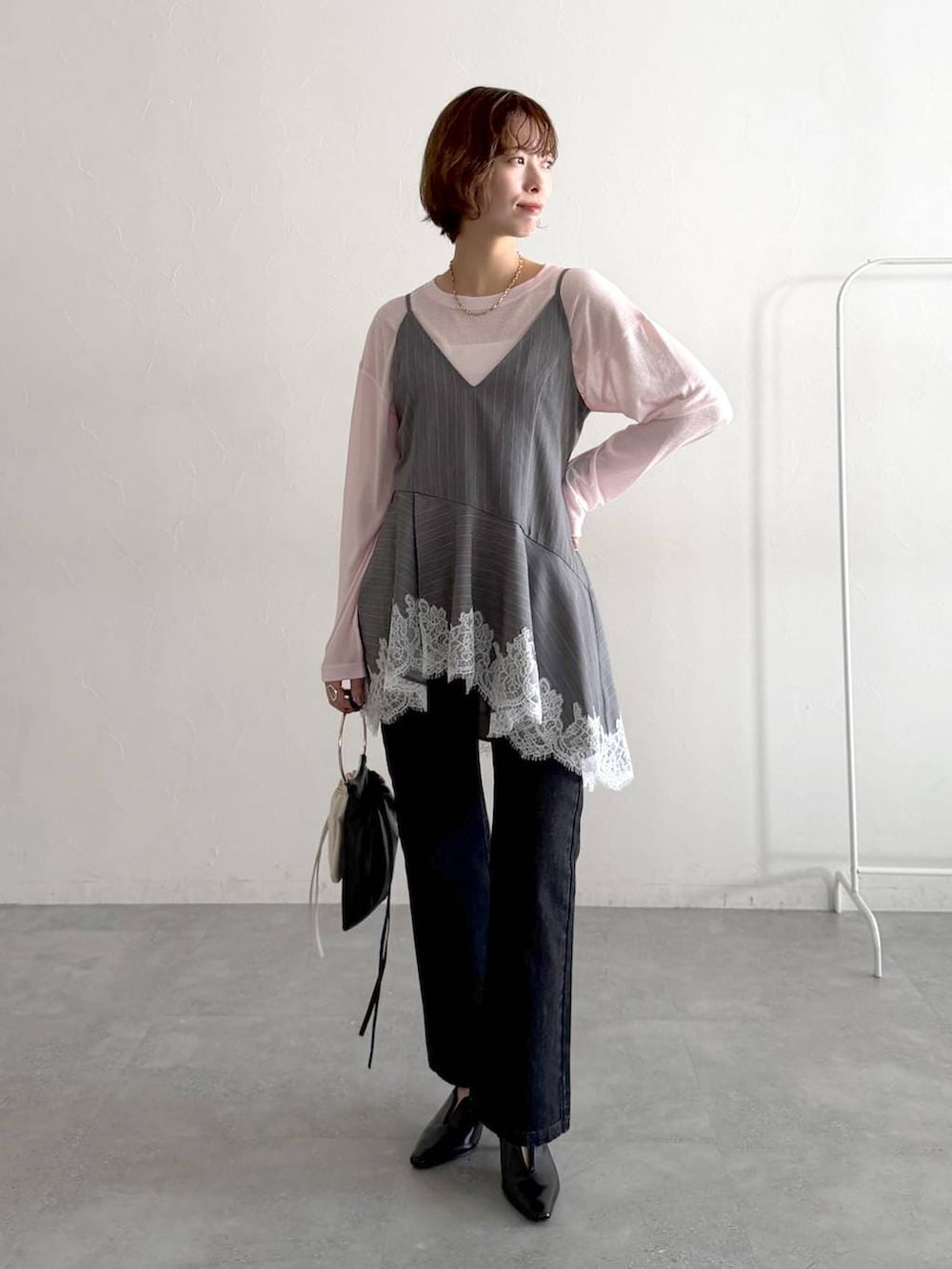 ピンク系のTシャツ/カットソー、ブラック系のデニムパンツ、ブラック系のサンダルを着用したレディースの春コーディネートの5枚目の写真