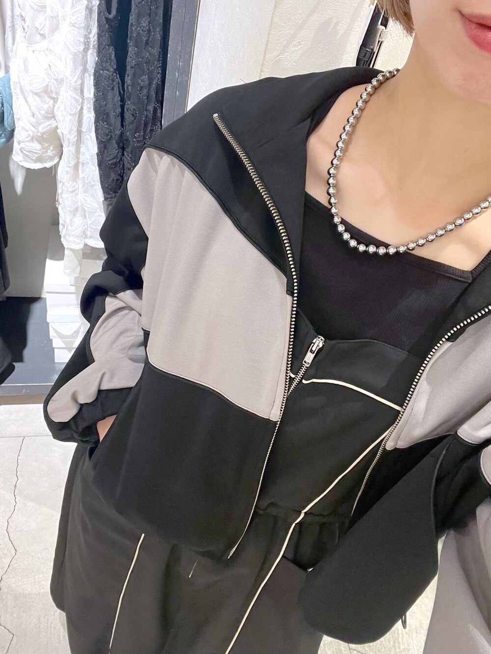 シルバー系のショルダーバッグ、ブラック系のブーツ、ブラック系のワンピースを着用したレディースの秋コーディネートの5枚目の写真