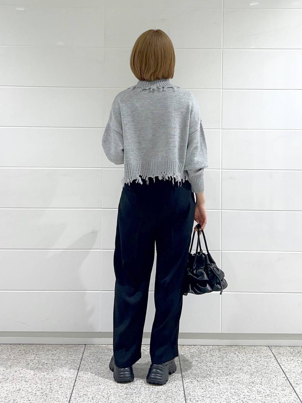 ブラック系のブーツ、ブラック系のショルダーバッグ、ホワイト系のその他アウターを着用したレディースの秋コーディネートの6枚目の写真