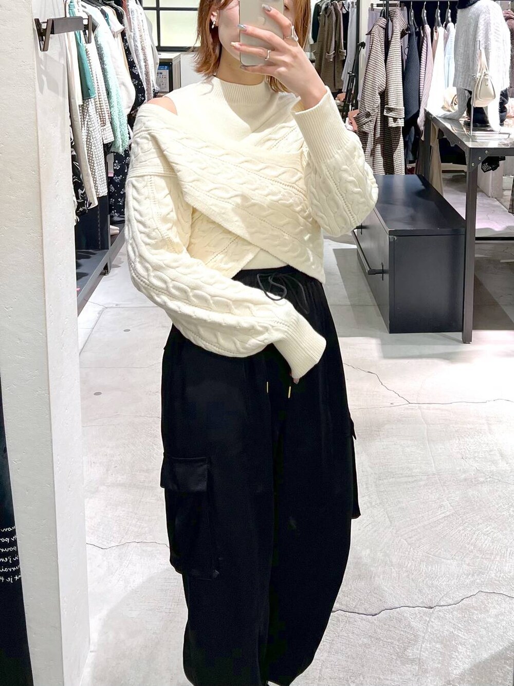 ブラック系のブーツ、グリーン系のハンドバッグ、ホワイト系のニット/セーターを着用したレディースの秋コーディネートの4枚目の写真