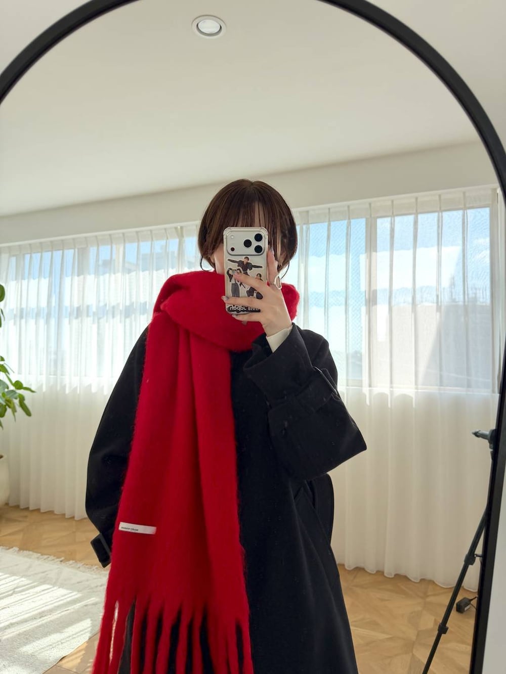ブルー系のデニムパンツ、ブラック系のショルダーバッグ、ブラック系のチェスターコートを着用したレディースの秋コーディネートの4枚目の写真