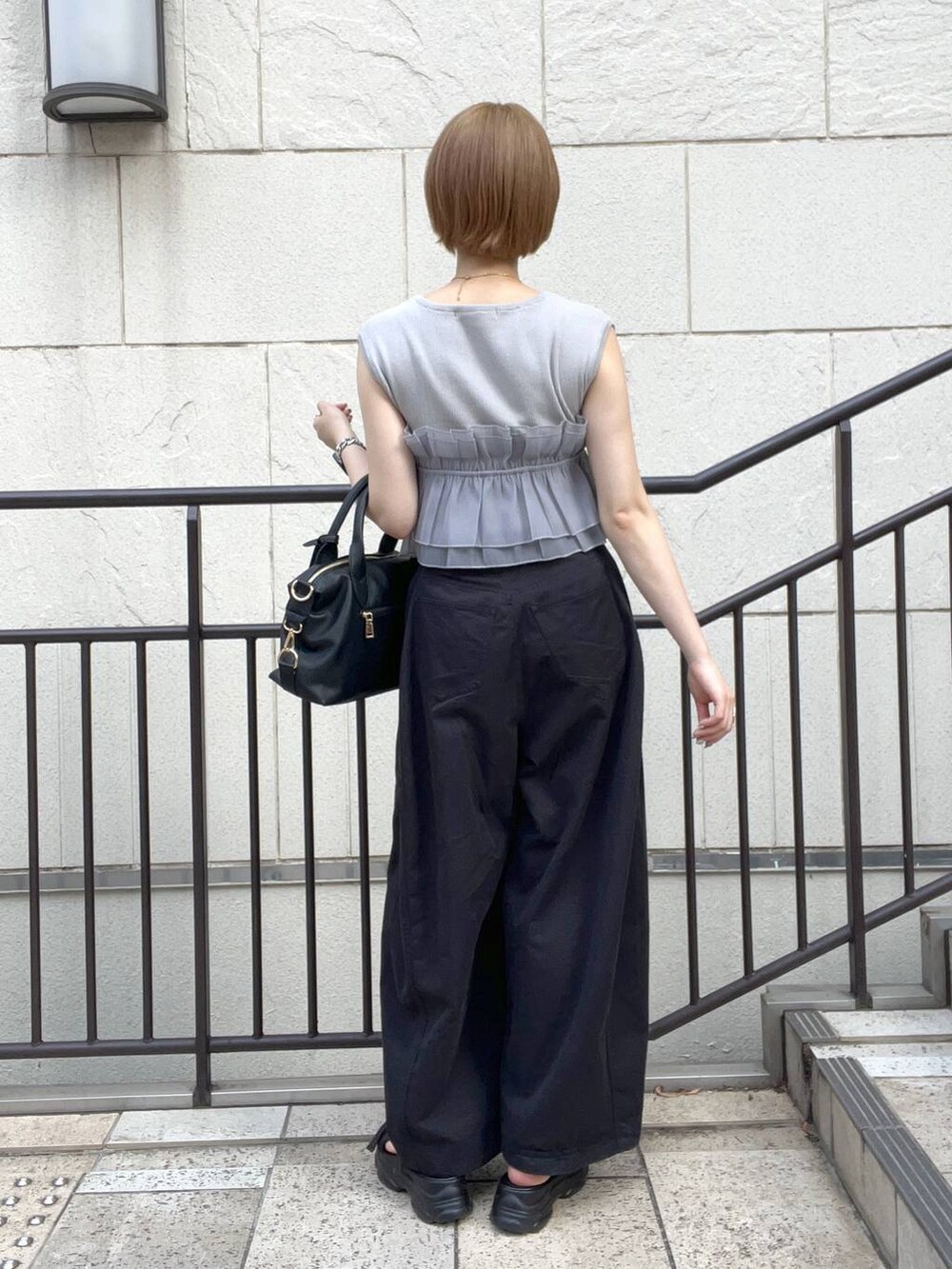 ブラック系のサンダル、ブラック系のその他パンツ、ブラック系のボストンバッグを着用したレディースの夏コーディネートの3枚目の写真