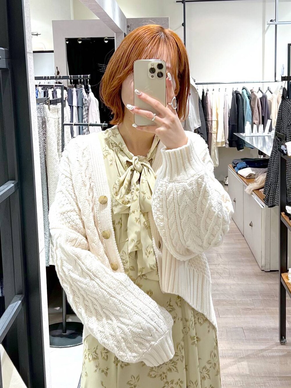 ブラウン系のハンドバッグ、ベージュ系のワンピース、ホワイト系のカーディガン/ボレロを着用したレディースの秋コーディネートの4枚目の写真