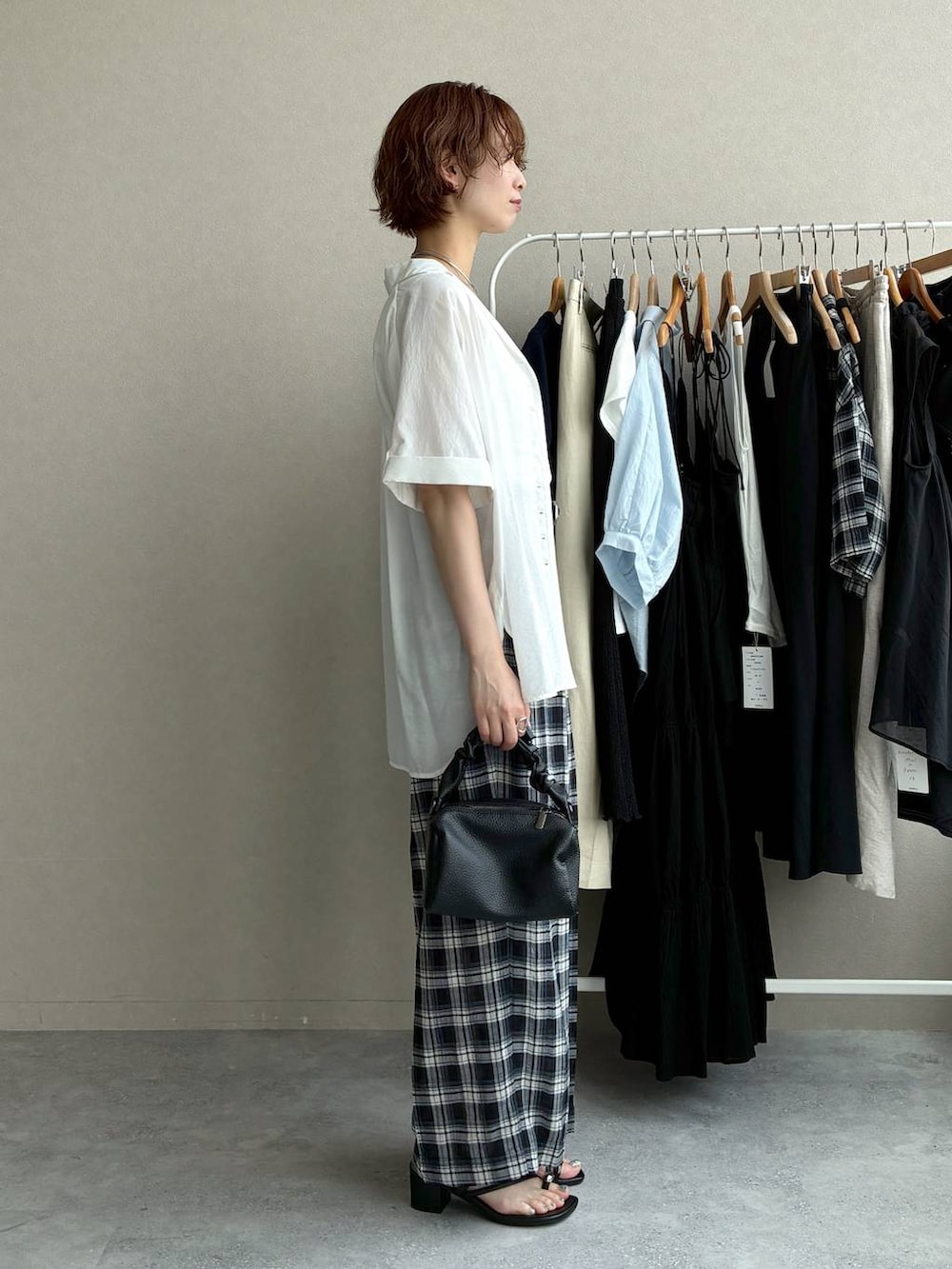 ブラック系のその他パンツ、ブラック系のショルダーバッグ、ホワイト系のシャツ/ブラウスを着用したレディースの夏コーディネートの2枚目の写真