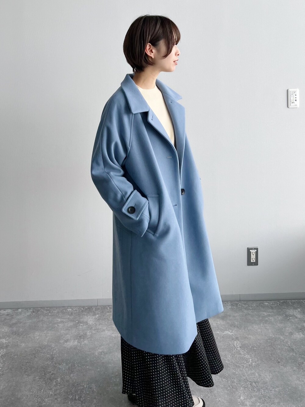 ホワイト系のニット/セーター、ブラック系のスカート、ホワイト系のブーツを着用したレディースの夏コーディネートの4枚目の写真